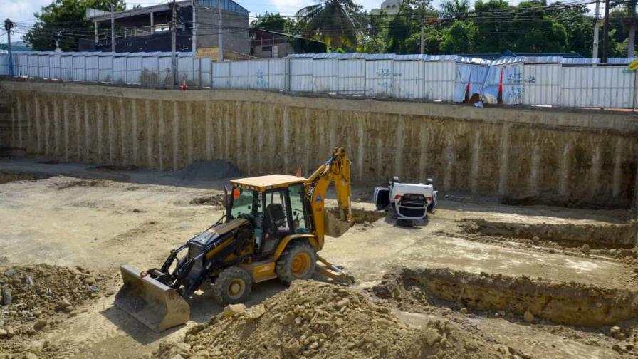 Dos hombres sobreviven al caer carro en hoyo de una construcción en Santiago