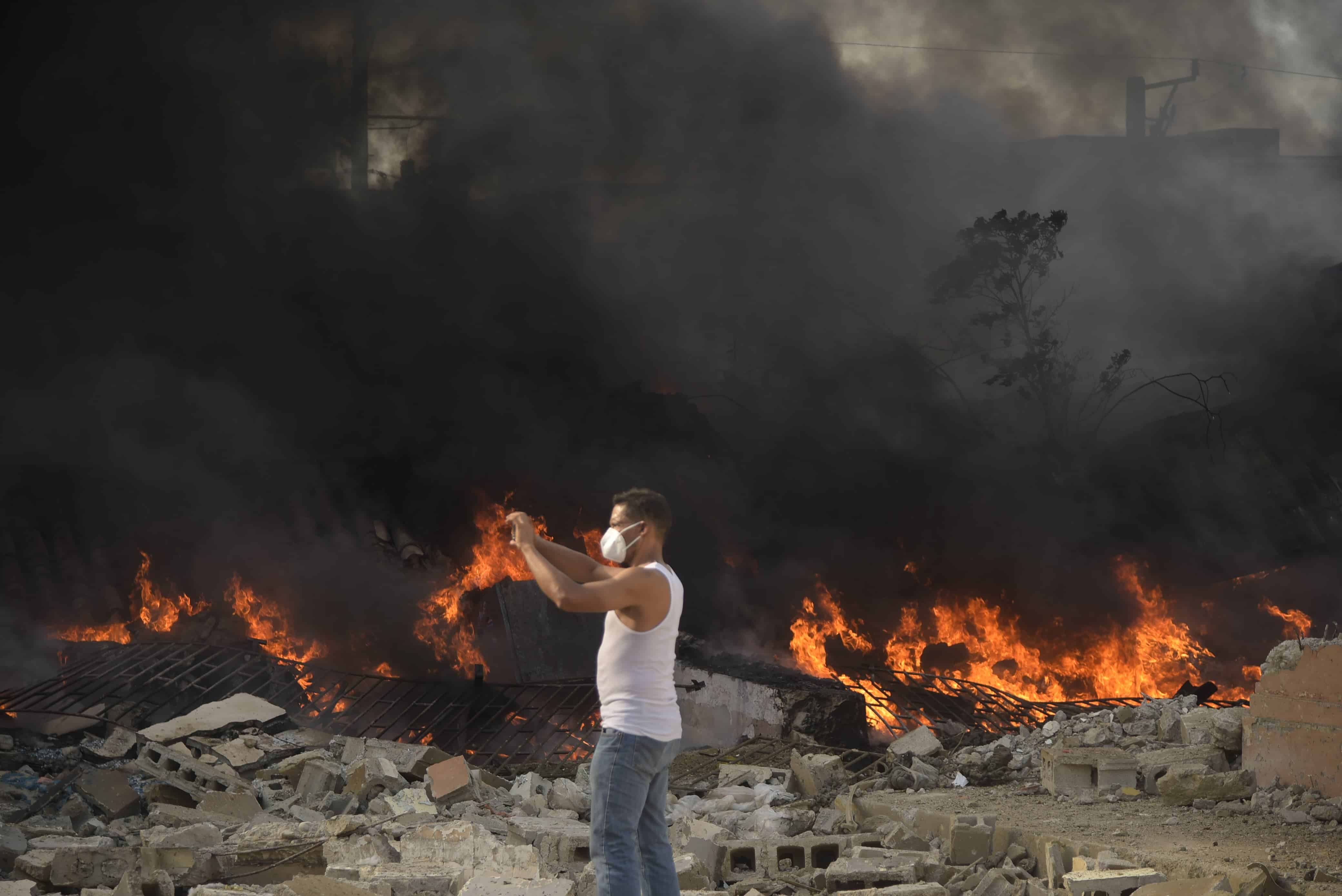 Un hombre graba con su celular cerca del lugar del incendio que provocó una explosión en San Cristóbal.