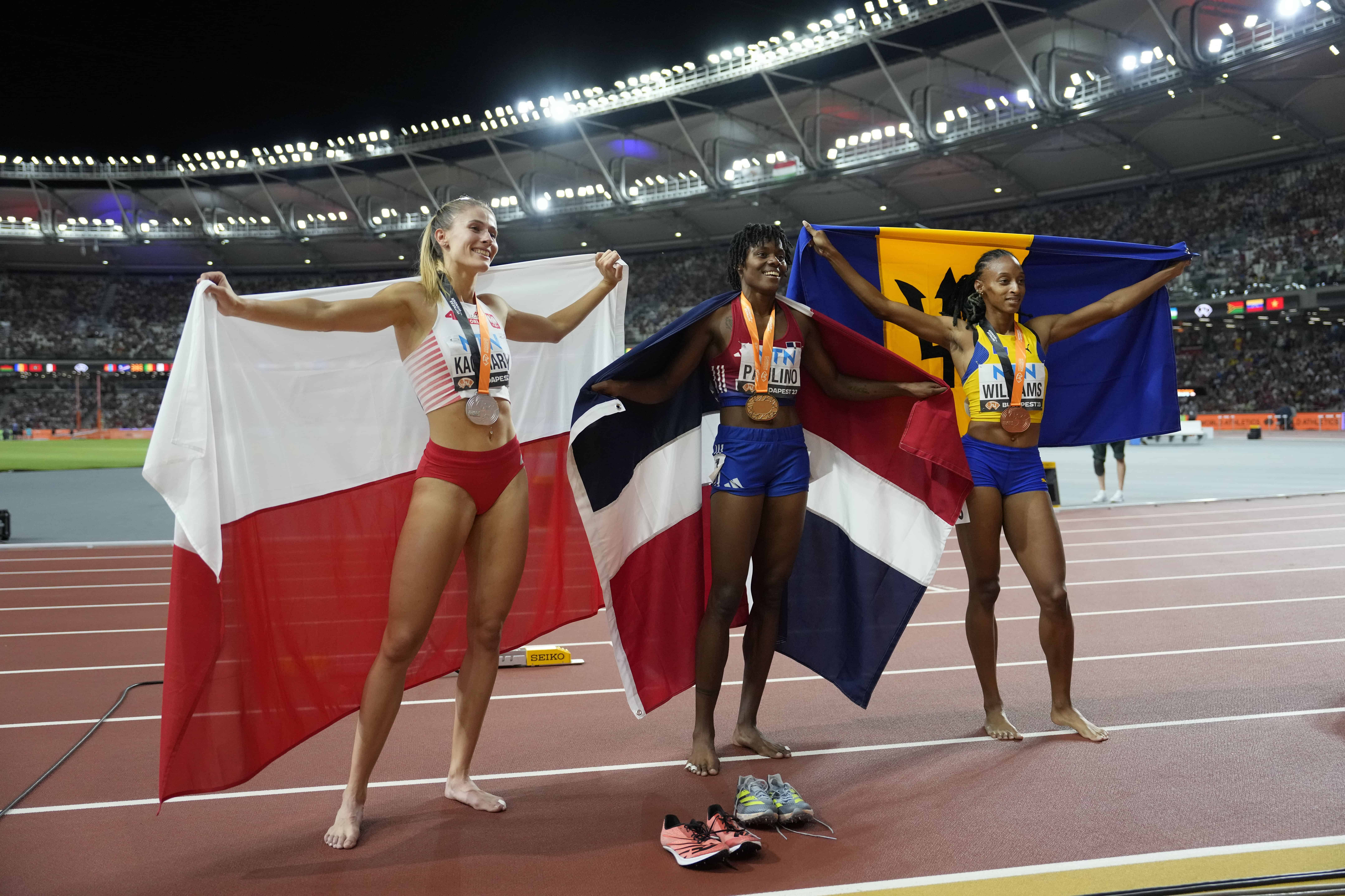 Natalia Kaczmarek, de Polonia, izquierda, Marileidy Paulino, de República Dominicana, y Sada Williams, de Barbados, posan después de competir en la final femenina de 400 metros durante el Campeonato Mundial de Atletismo en Budapest, Hungría, el miércoles 23 de agosto de 2023.