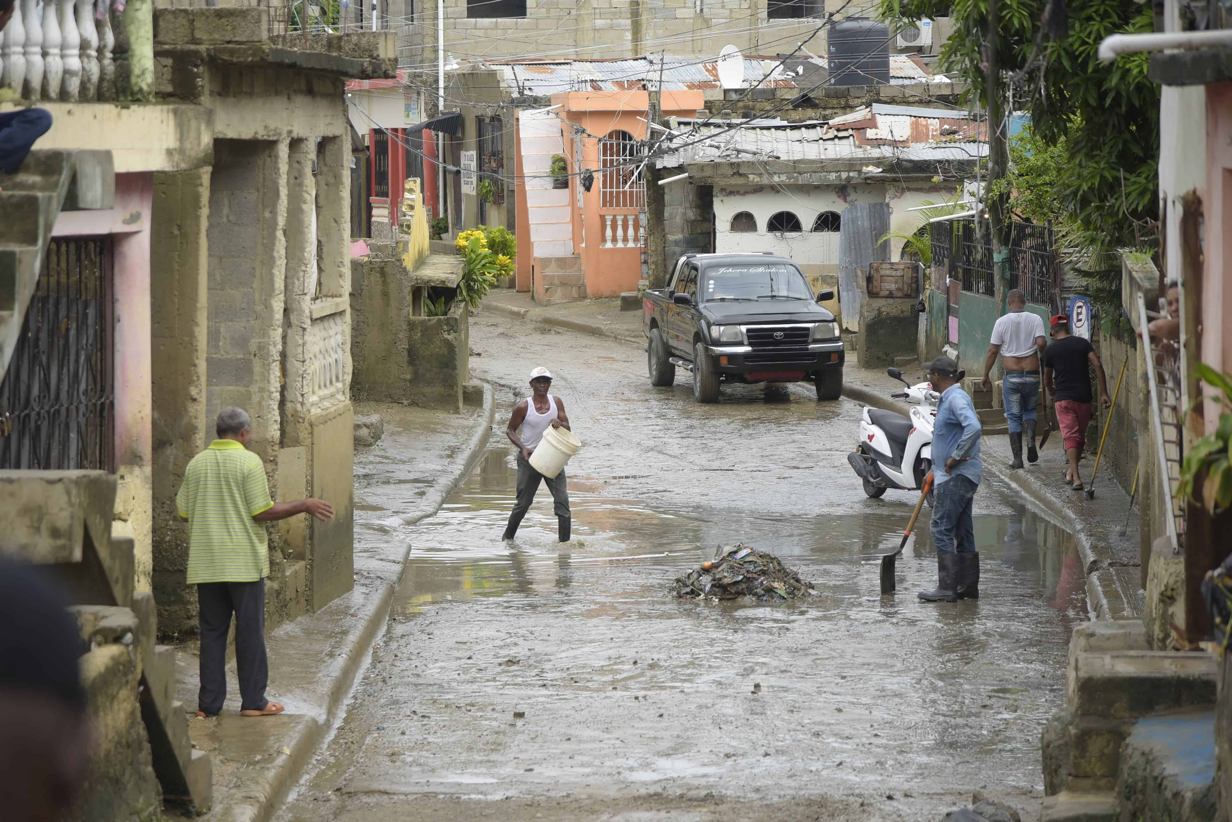 Residentes en Guaricano sacando el agua de los hogares