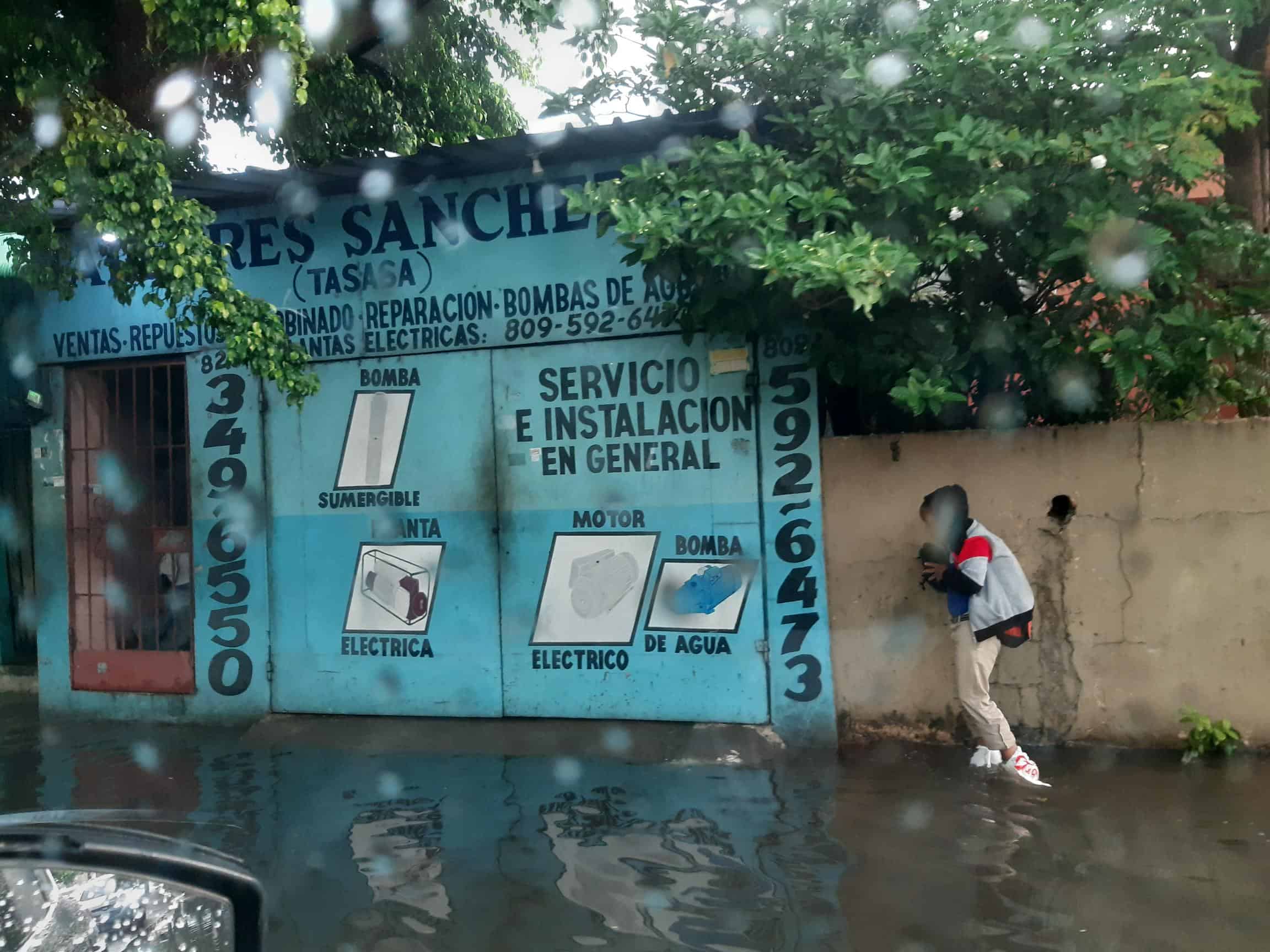 Estudiantes se colocan fundas en los pies para salir a la escuela en la avenida 25 de Febrero.