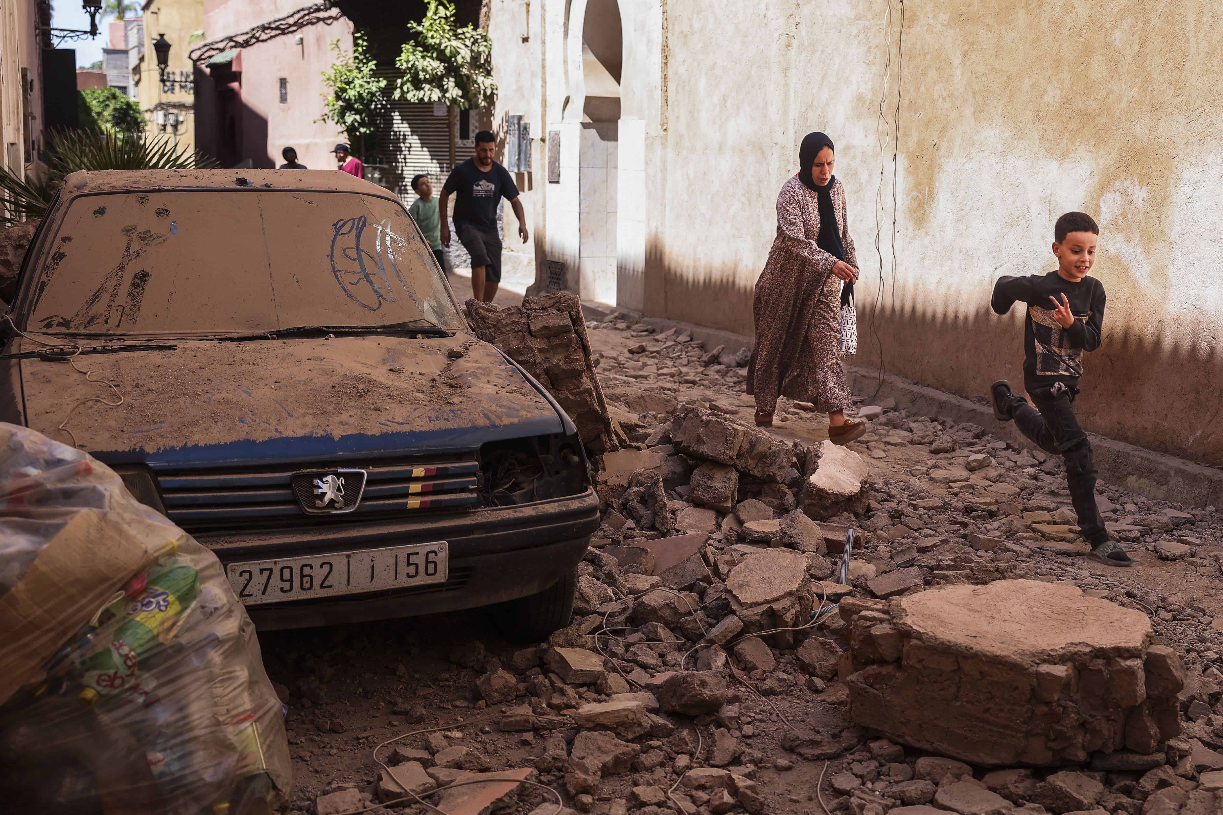 La gente camina por una calle con edificios dañados que se derrumbaron en un poderoso terremoto en Marrakech, Marruecos, 10 de septiembre de 2023.