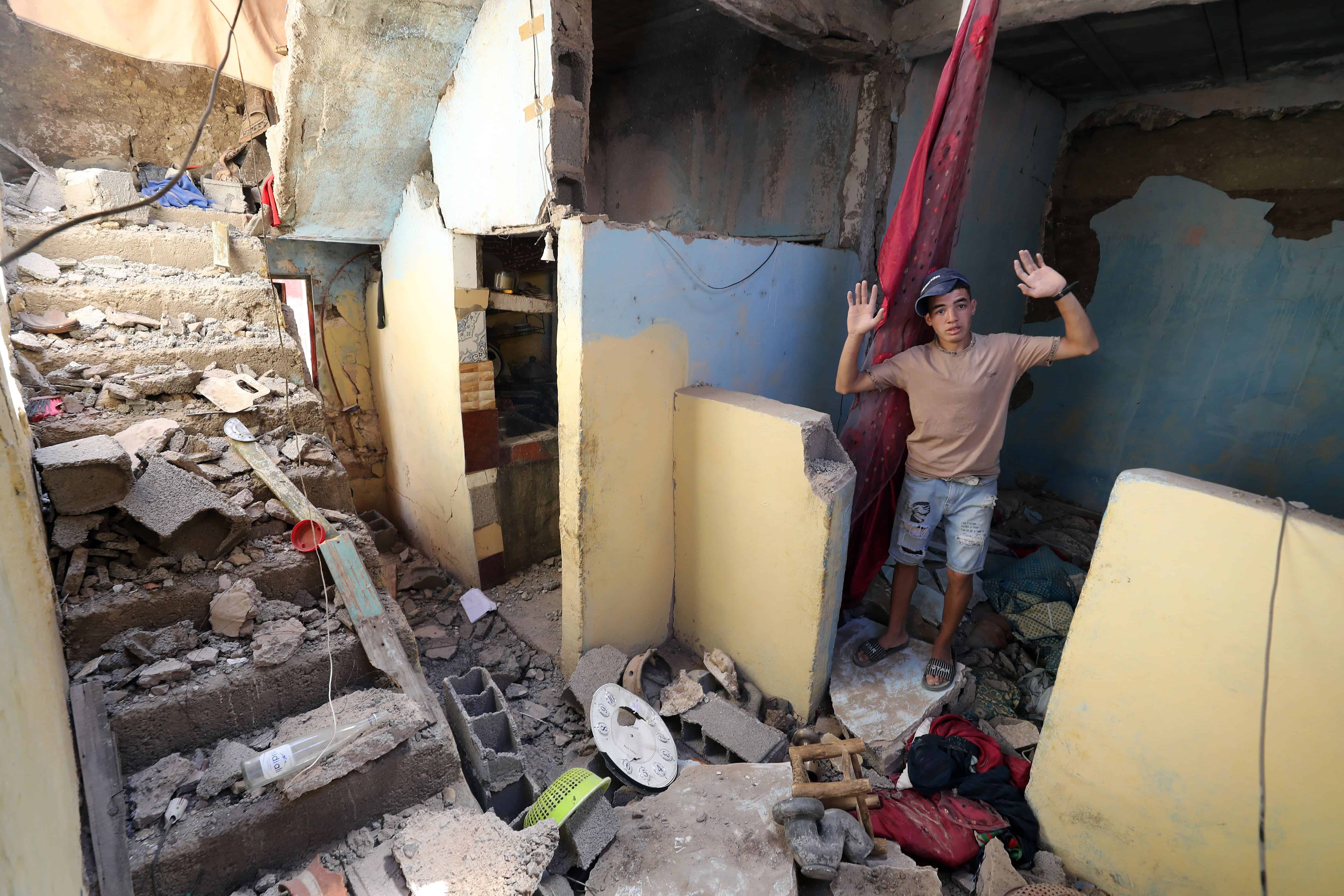 Un niño reacciona mientras se encuentra entre los escombros dentro de su casa dañada, en Moulay Brahim.