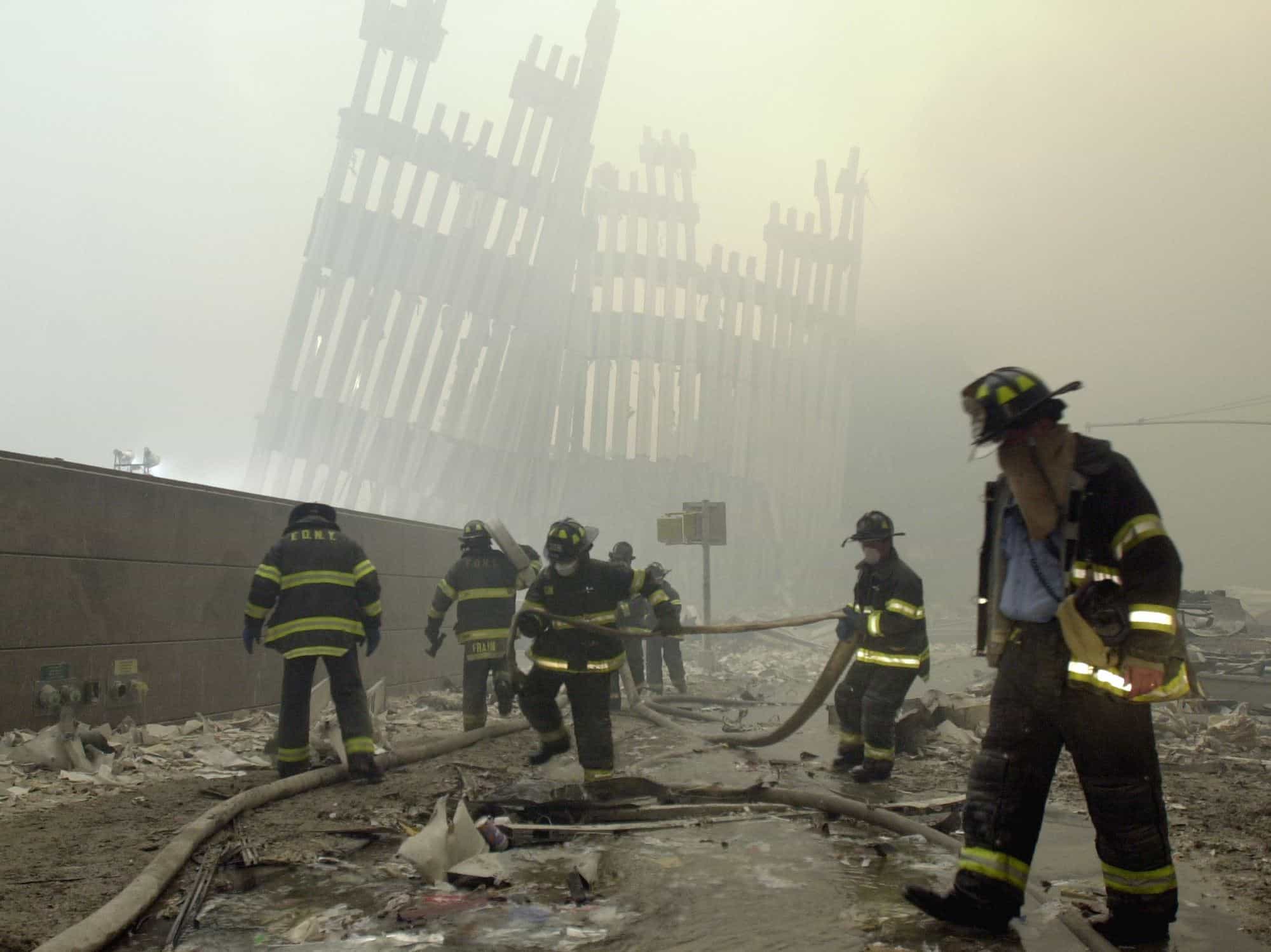 ARCHIVO - Los bomberos trabajan debajo de los parteluces destruidos, los puntales verticales que alguna vez estuvieron frente a las altísimas paredes exteriores de las torres del World Trade Center, después de un ataque terrorista en Nueva York, el 11 de septiembre de 2001.