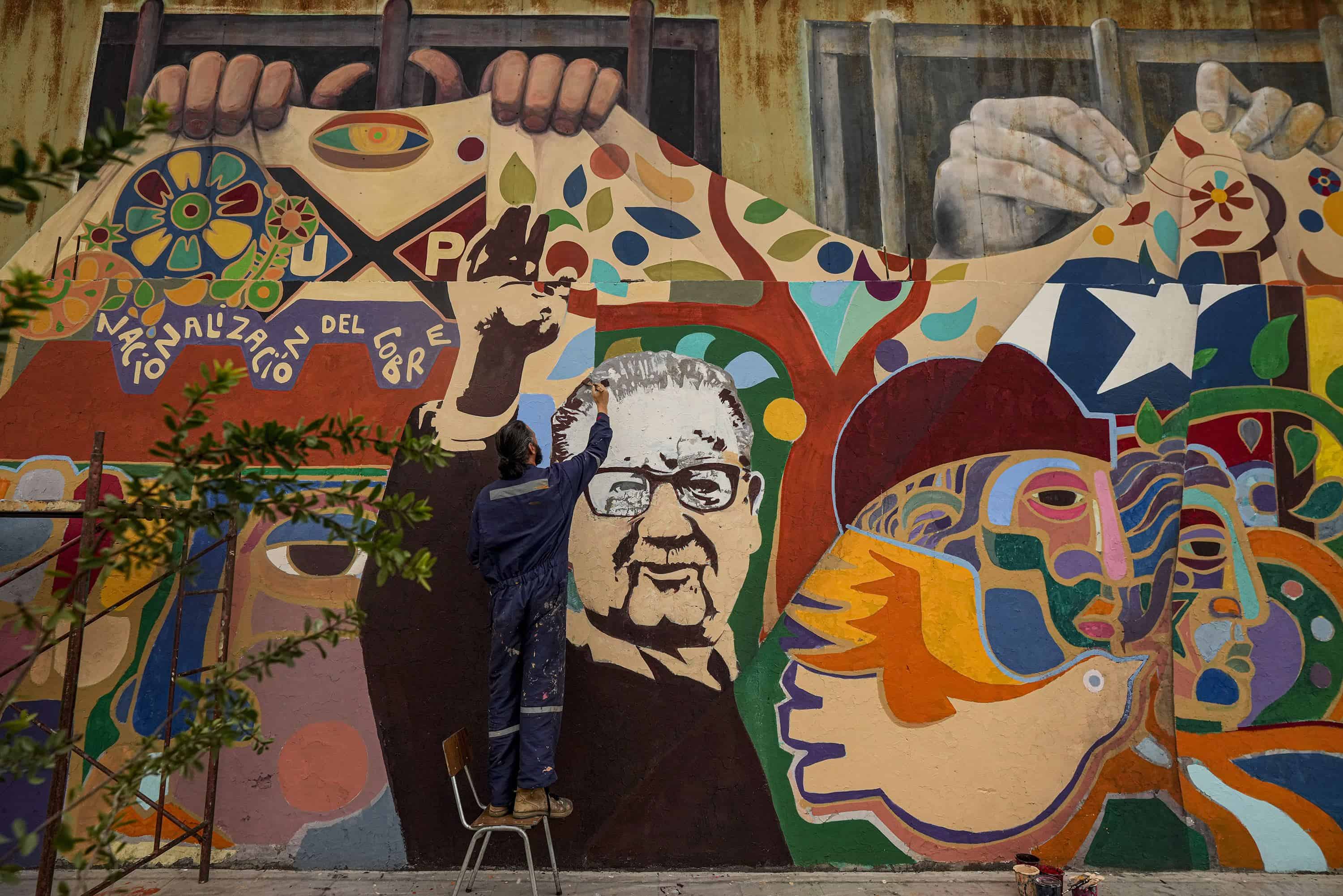 El pintor y muralista Ian Pierce trabaja en la restauración del mural Memoria, futuro, en honor al fallecido presidente de Chile, Salvador Allende, frente a un centro de detención controlado por el régimen de Augusto Pinochet, en Santiago, Chile, el viernes 8 de septiembre. , 2023. Pinochet encabezó un golpe militar el 11 de septiembre de 1973, que incluyó el bombardeo del palacio presidencial en la capital de Santiago, donde Allende se había refugiado. Allende se suicidó durante el asalto.