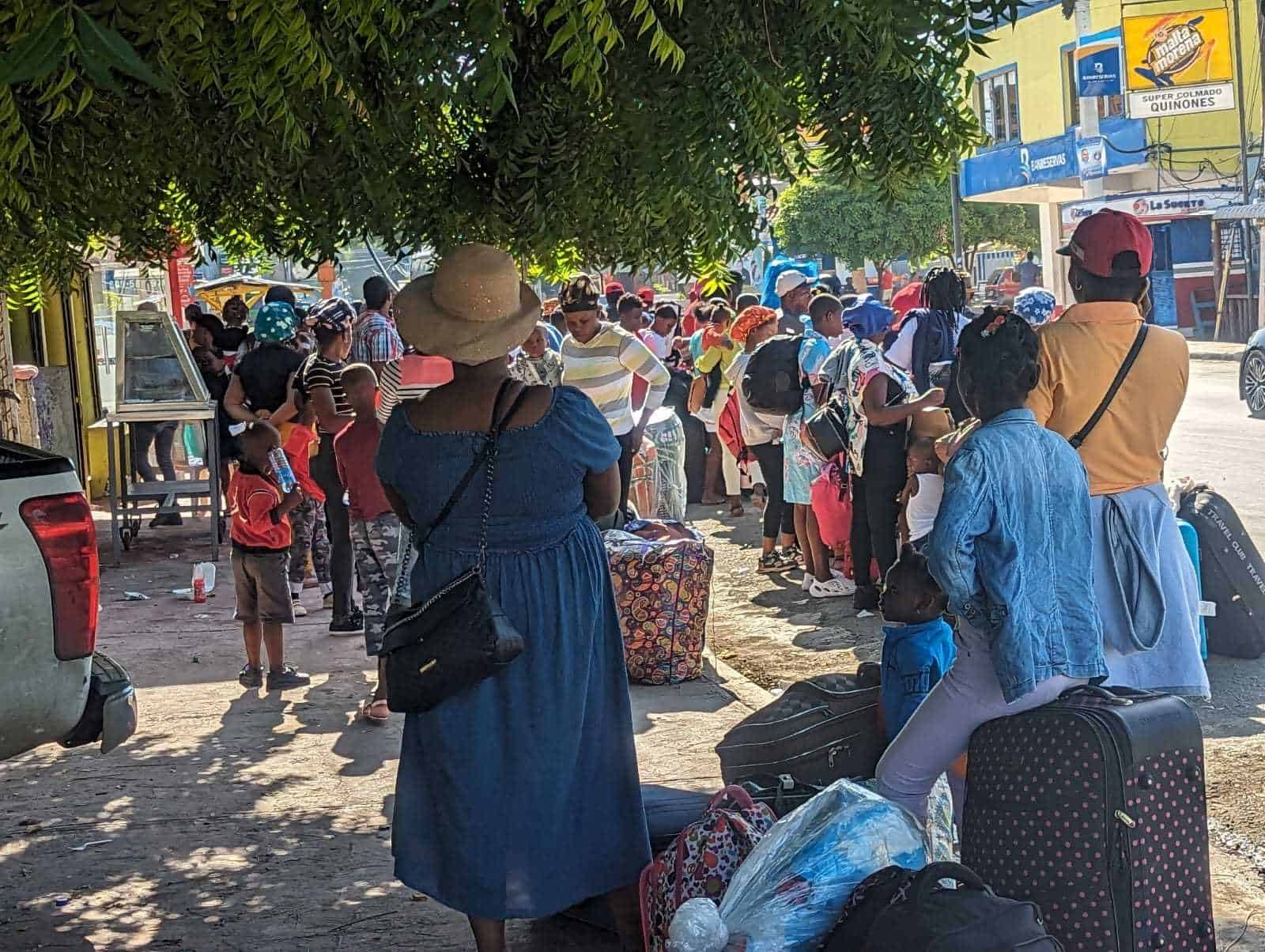 Haitianos esperan transporte para trasladarse desde Valverde a Dajabón y luego hacia su país.