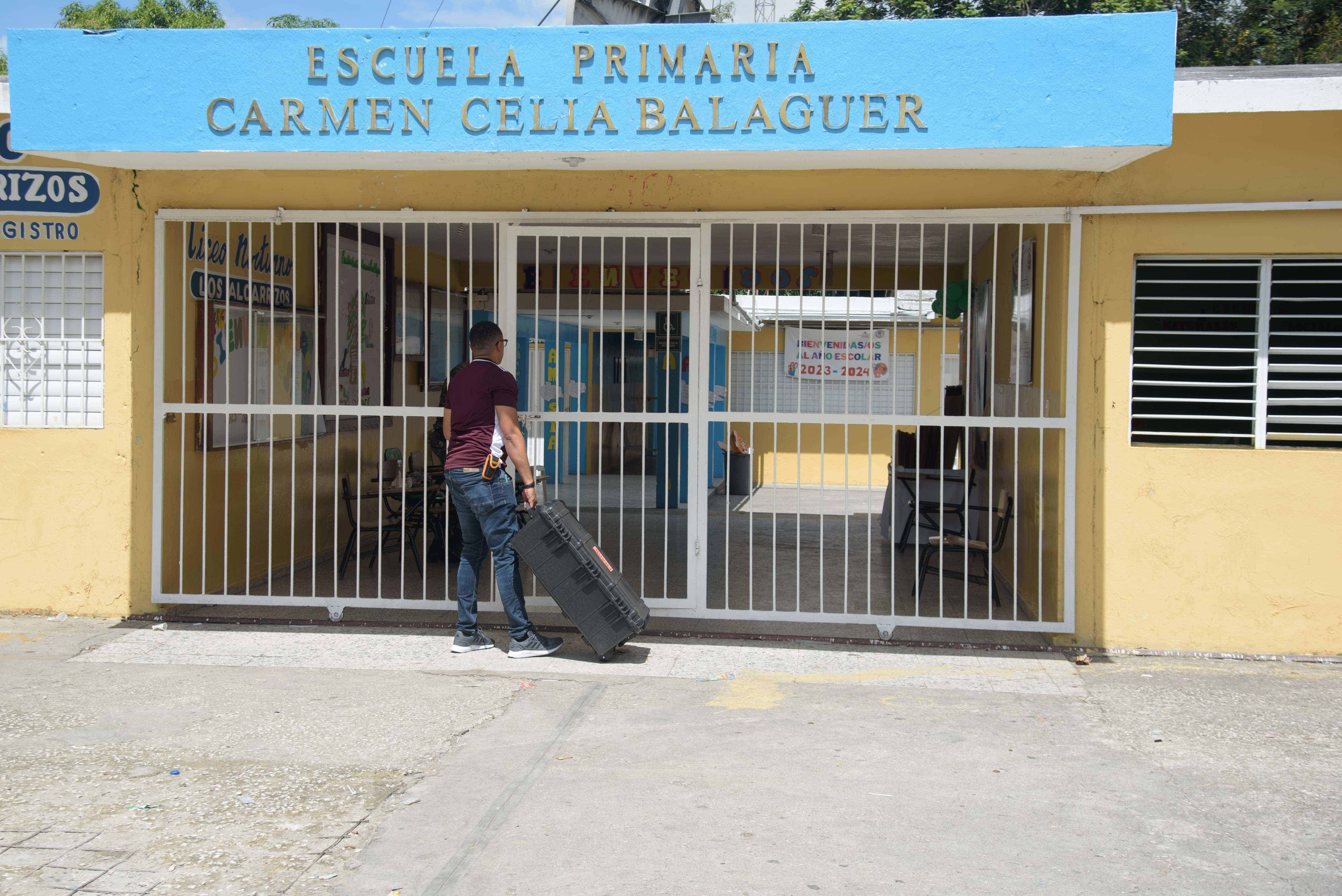 Técnicos del JCE llegan con las valijas a la Escuela Primaria Carmen Celia Balaguer.