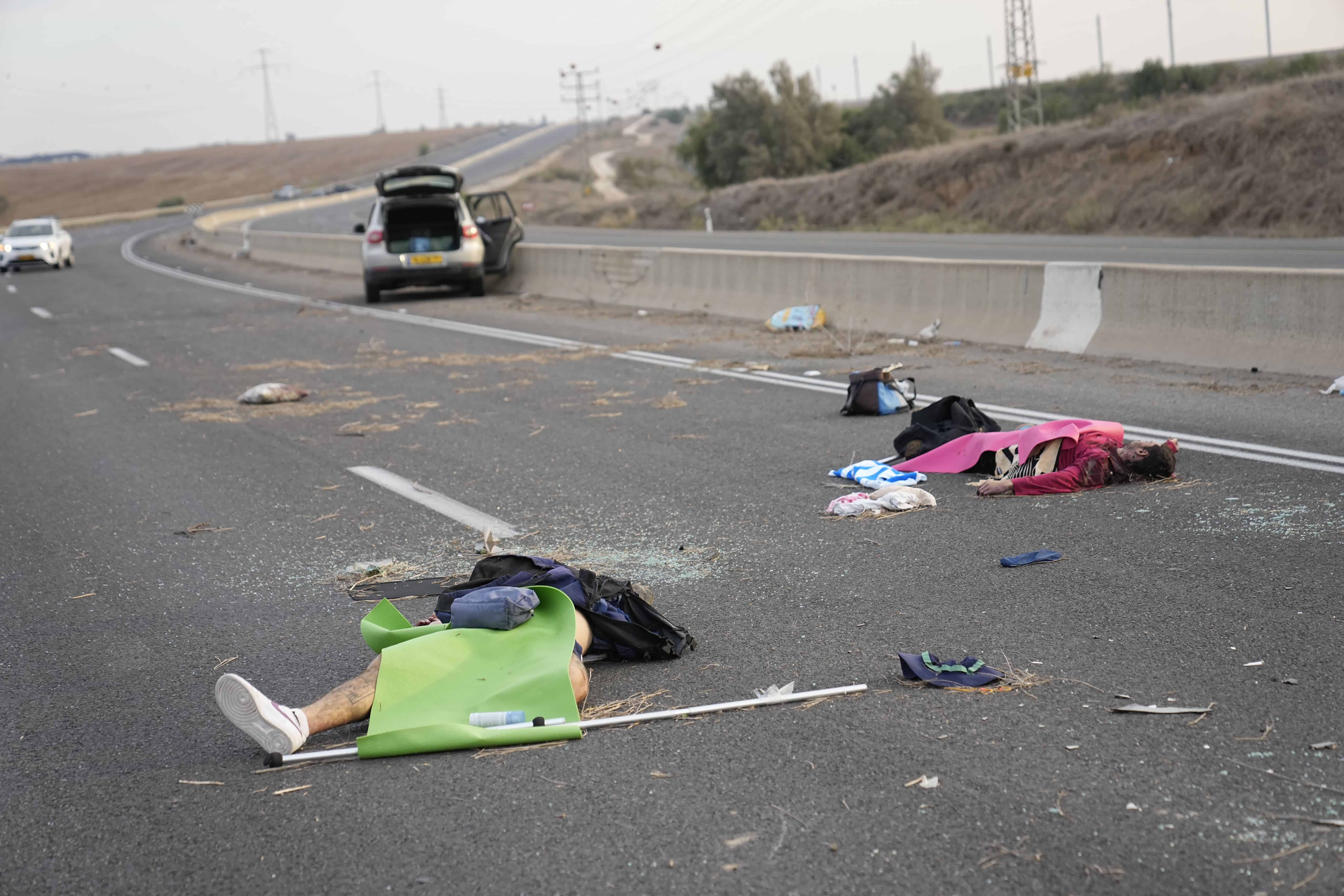 Hombres armados palestinos yacen en la carretera cerca de Sderot, Israel, el sábado 7 de octubre de 2023.