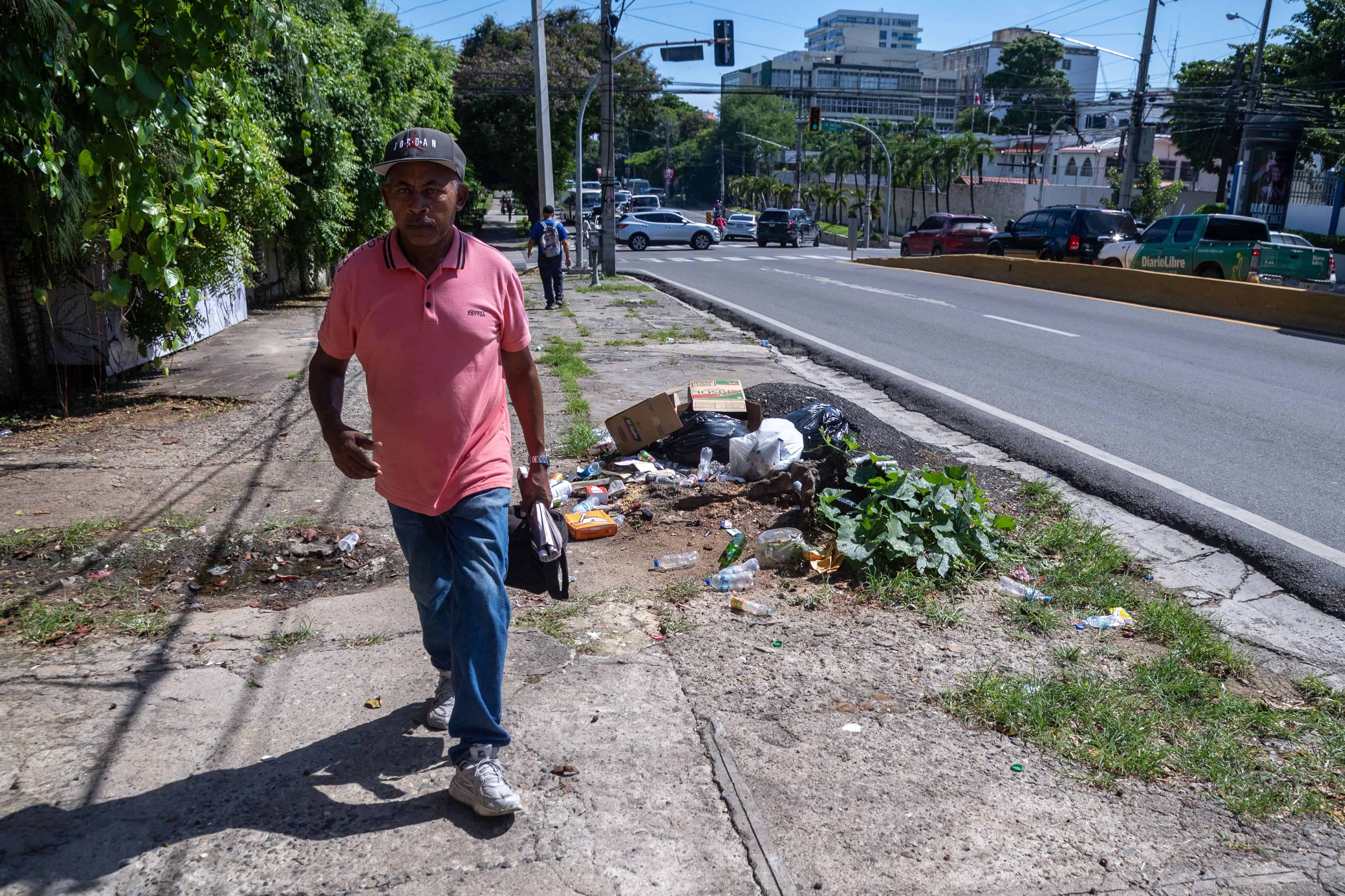 Caminando al lado de la inmundicia. Un hombre camina junto a desechos esparcidos en la avenida Máximo Gómez, próximo a la avenida Pedro Henríquez Ureña, en el Distrito Nacional, el 6 de octubre de 2023.