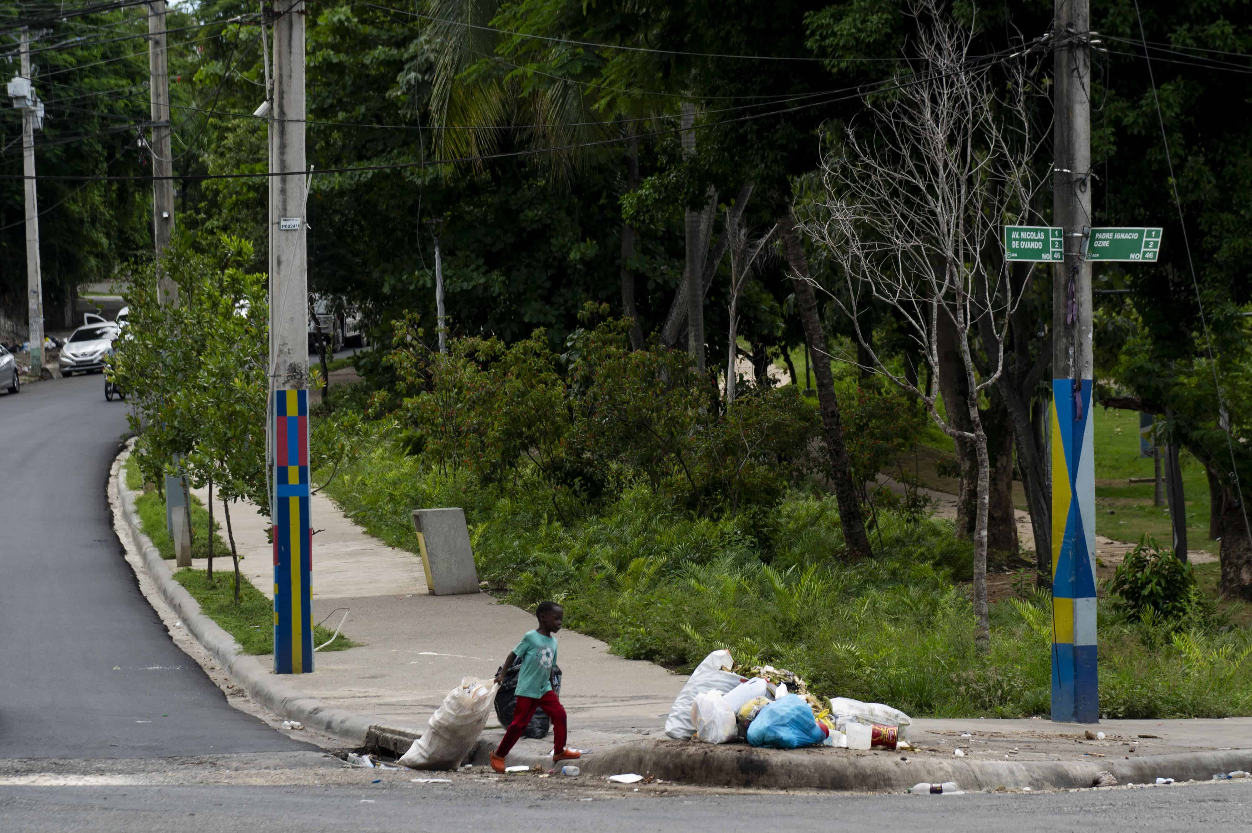 Un niño carga desechos. Un niño arrastra una funda de basura en la intersección de la Av. Nicolás de Ovando con la calle Padre Ignacio Ozmee, en el sector Cristo Rey, el 26 de septiembre de 2023.