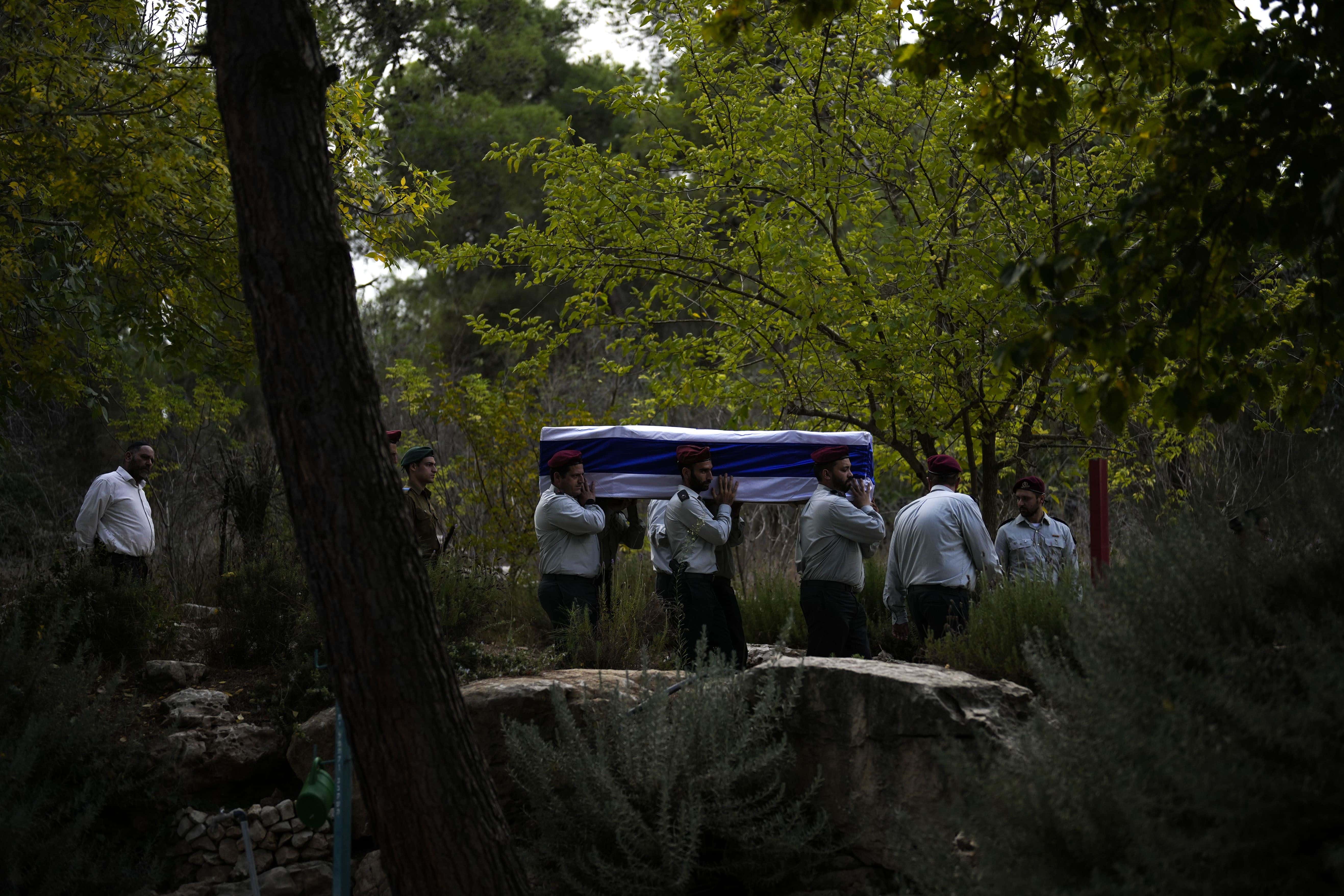 Soldados israelíes cargan un féretro cubierto con la bandera de Israel en el que yace el mayor Tal Cohen durante su funeral en el cementerio Givat Shaul, el martes 10 de octubre de 2023, en Jerusalén.