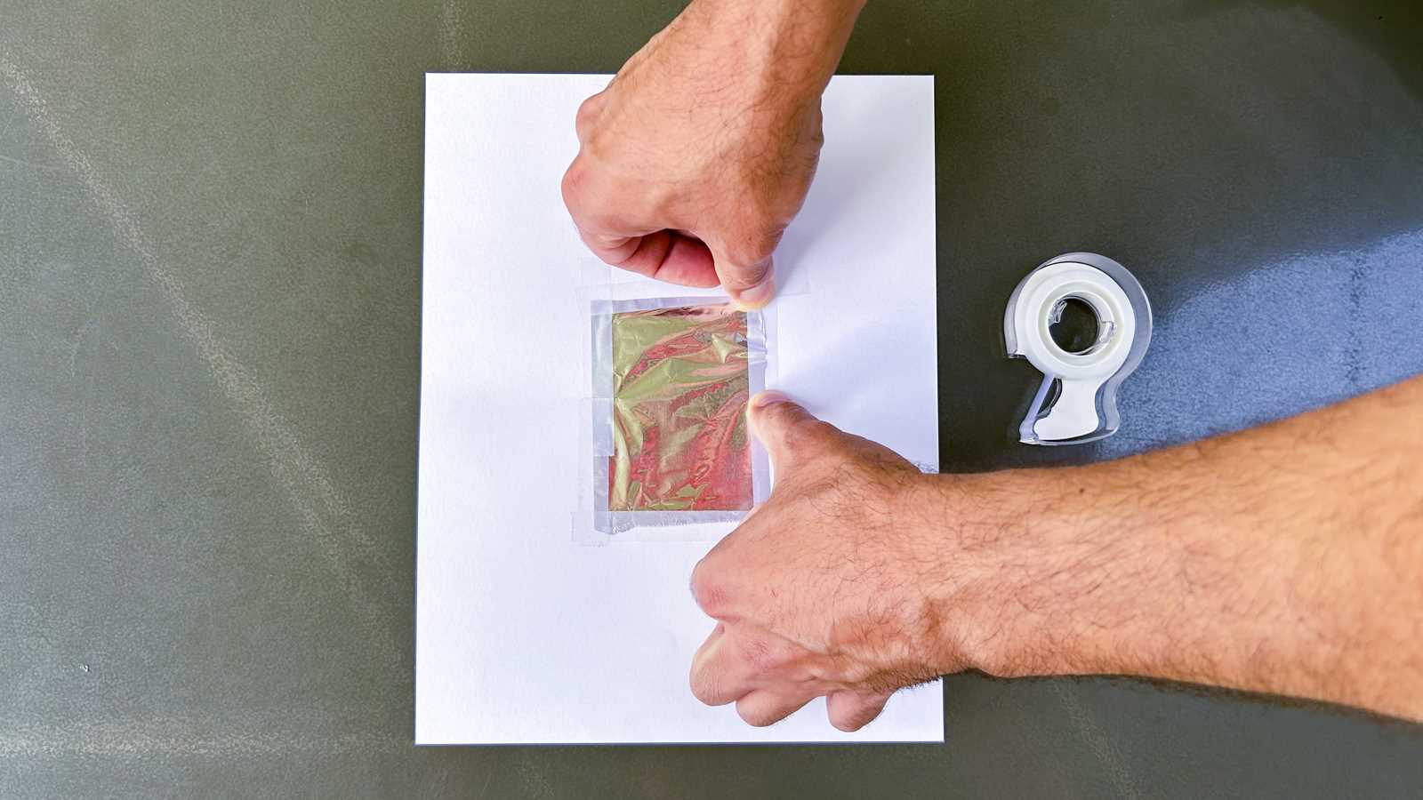 Posteriormente se recorta un cuadrado de papel aluminio un poco más grande que el agujero realizado en el cartonite y se pega por los cuatro lados con cinta adhesiva.