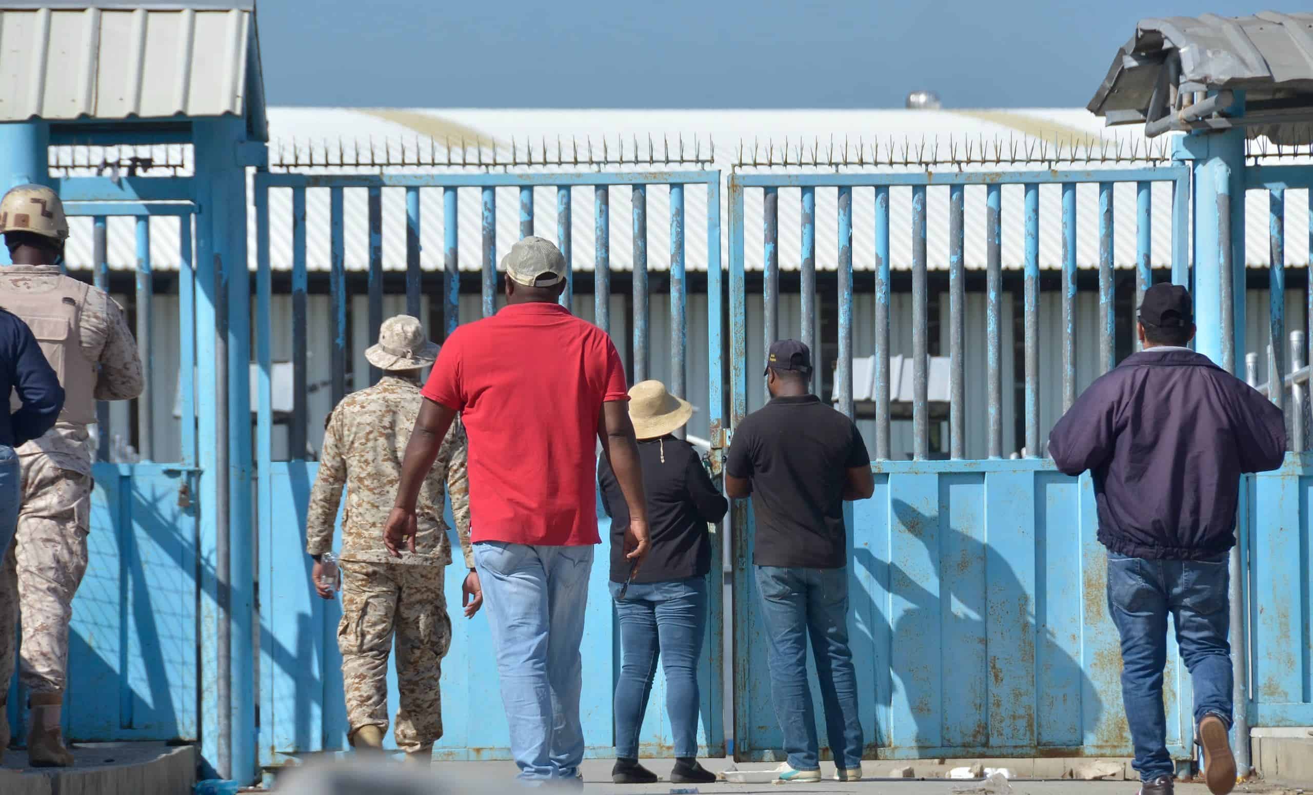 Militares y ciudadanos en la puerta que cierra la frontera dominicana con Haití en Dajabón.