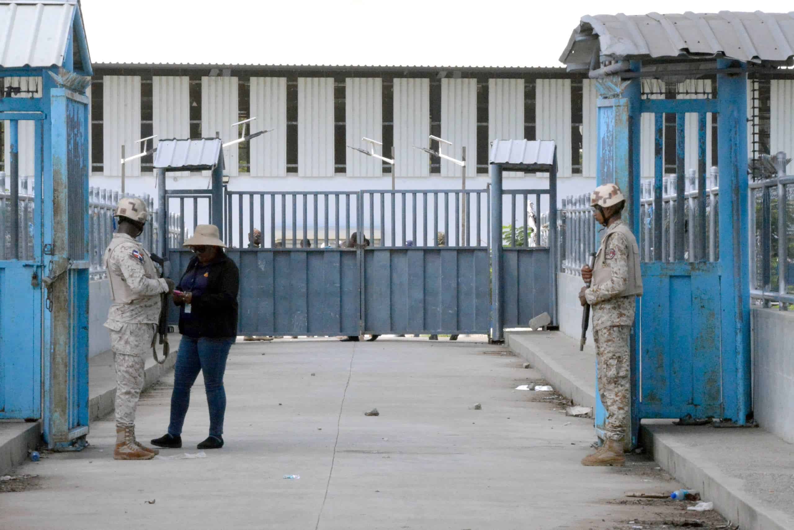 Militares dominicanos vigilan la puerta en la frontera de Dajabón.