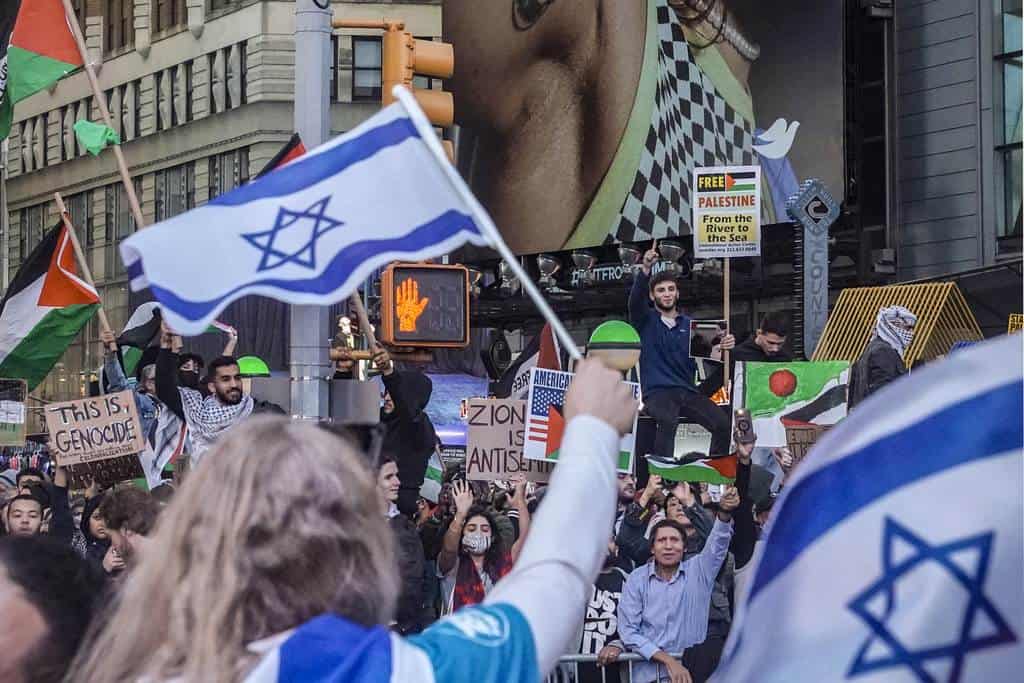 Partidarios de Israel, en primer plano, sostienen banderas mientras se manifiestan frente a la calle 42 de partidarios palestinos, el viernes 13 de octubre de 2023, en Nueva York, mientras continúa la guerra entre Israel y Hamas.