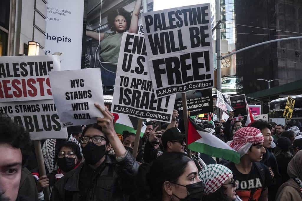 Simpatizantes palestinos marchan con banderas y carteles mientras cantan en protesta, el viernes 13 de octubre de 2023, en Nueva York, mientras continúa la guerra entre Israel y Hamas.