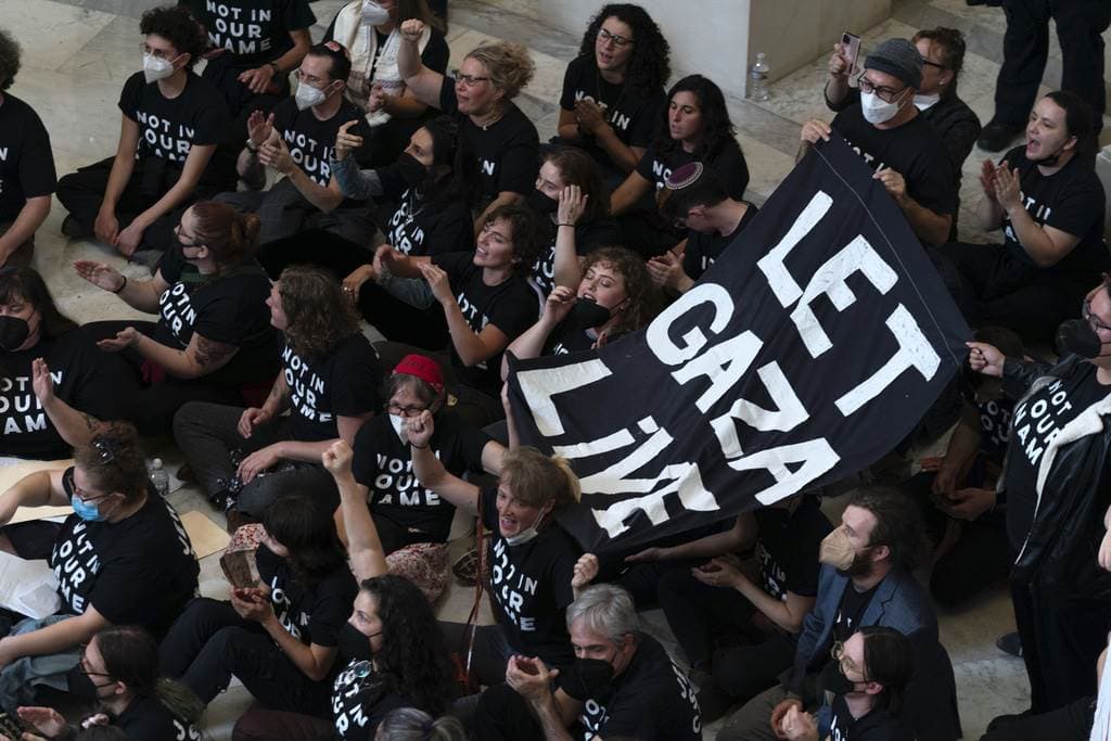 Manifestantes protestan dentro del edificio de oficinas Cannon House en Capitol Hill en Washington, el miércoles 18 de octubre de 2023.