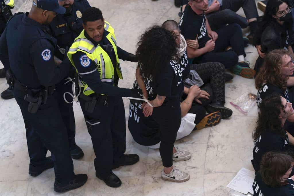 Agentes de la Policía del Capitolio de Estados Unidos detienen a manifestantes que protestaban dentro del edificio de oficinas de Cannon House en Capitol Hill en Washington, el miércoles 18 de octubre de 2023.