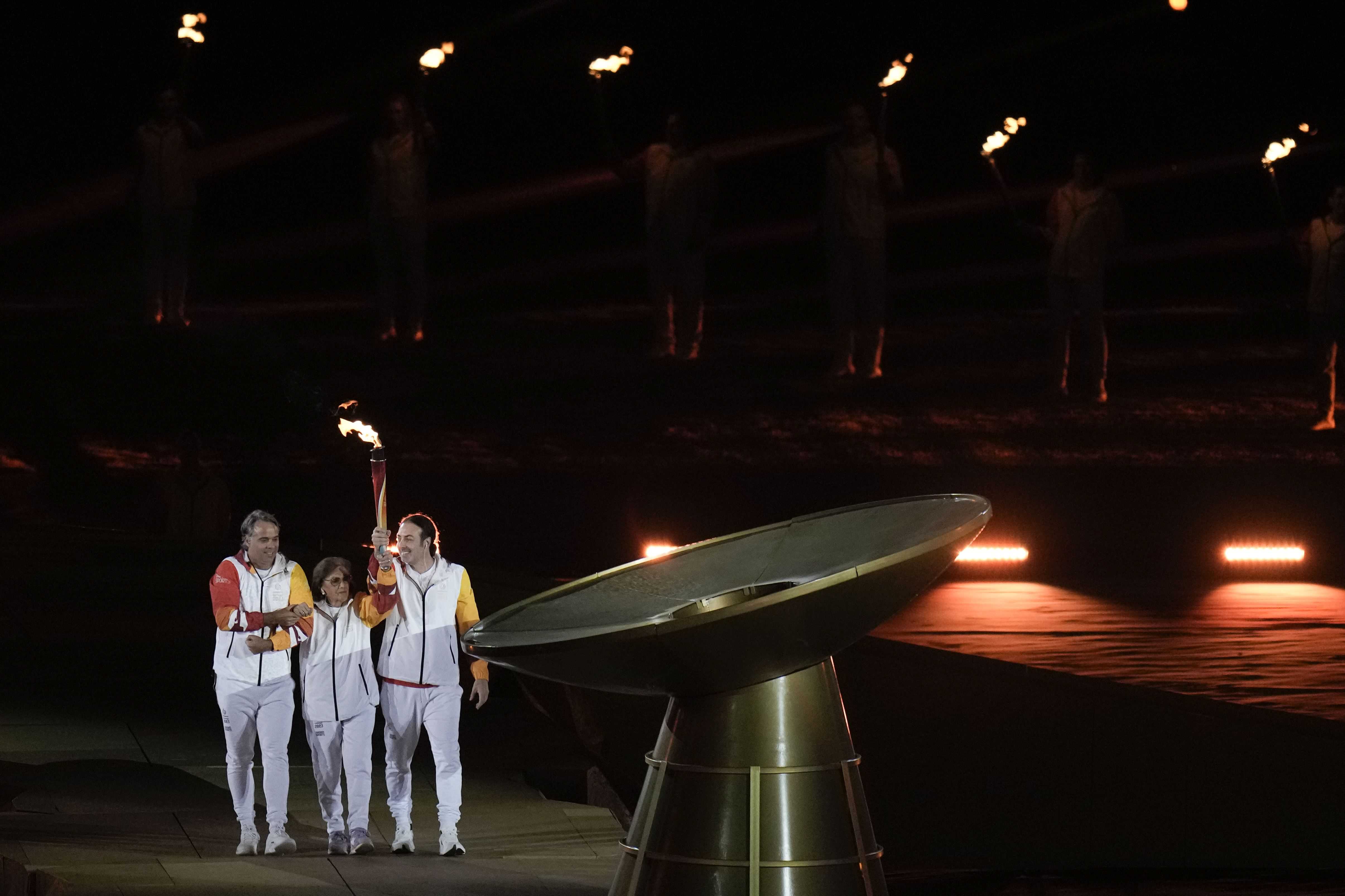 Portadores de la antorcha sostienen la antorcha para encender el pebetero durante la ceremonia inaugural de los Juegos Panamericanos en Santiago, Chile, el viernes 20 de octubre de 2023.