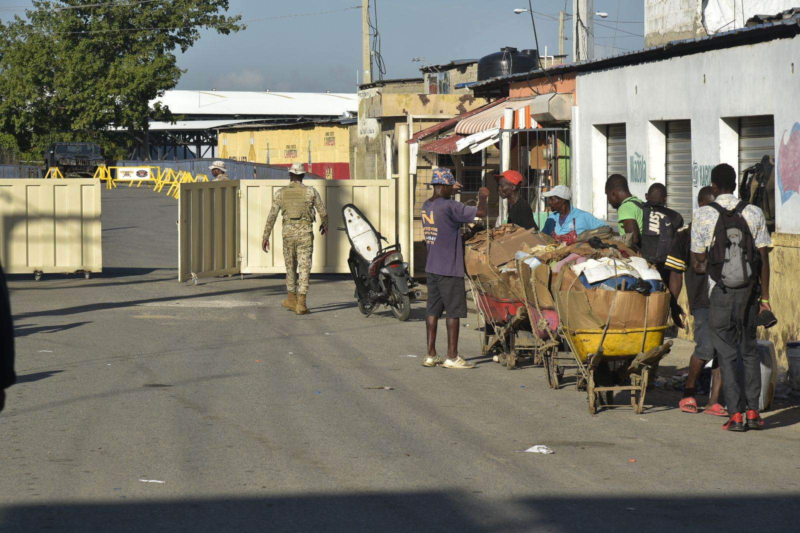 Haitianos esperan para cruzar el portón fronterizo del lado haitiano, el 23 de octubre del 2023.