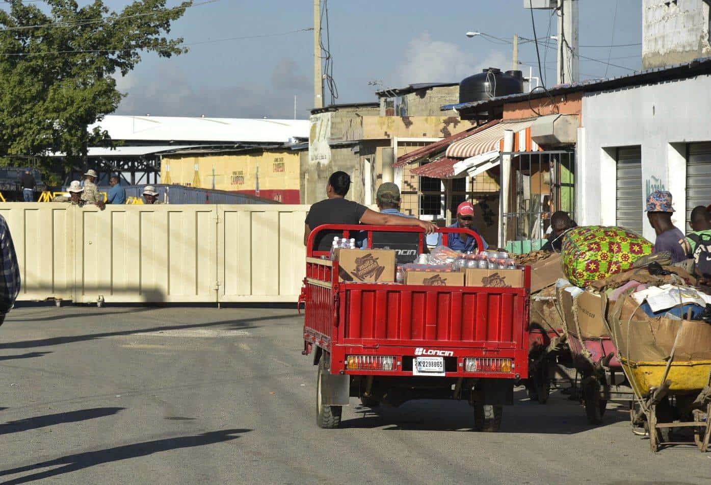 Haitianos esperan para cruzar el portón fronterizo del lado haitiano, el 23 de octubre del 2023.