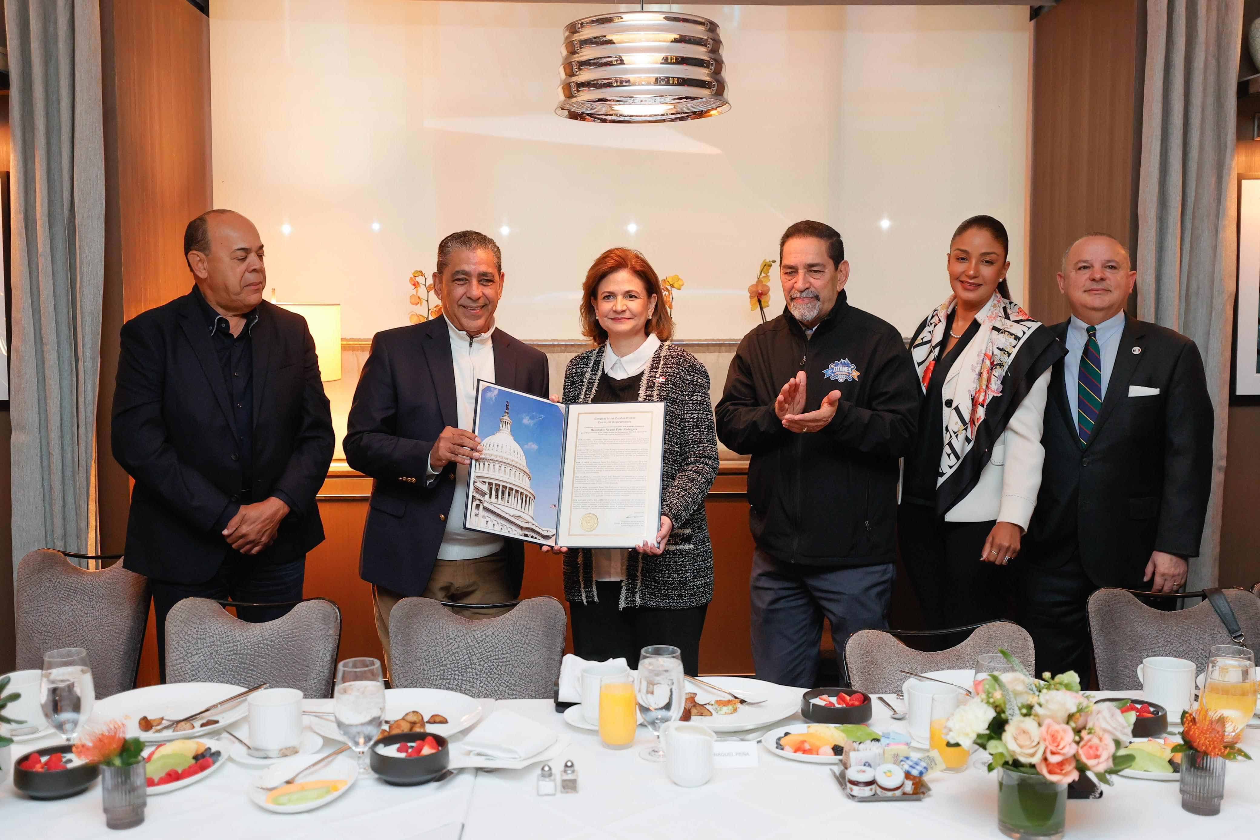 El congresista Adriano Espaillat sostiene un reconocimiento junto a la vicepresidenta Raquel Peña.