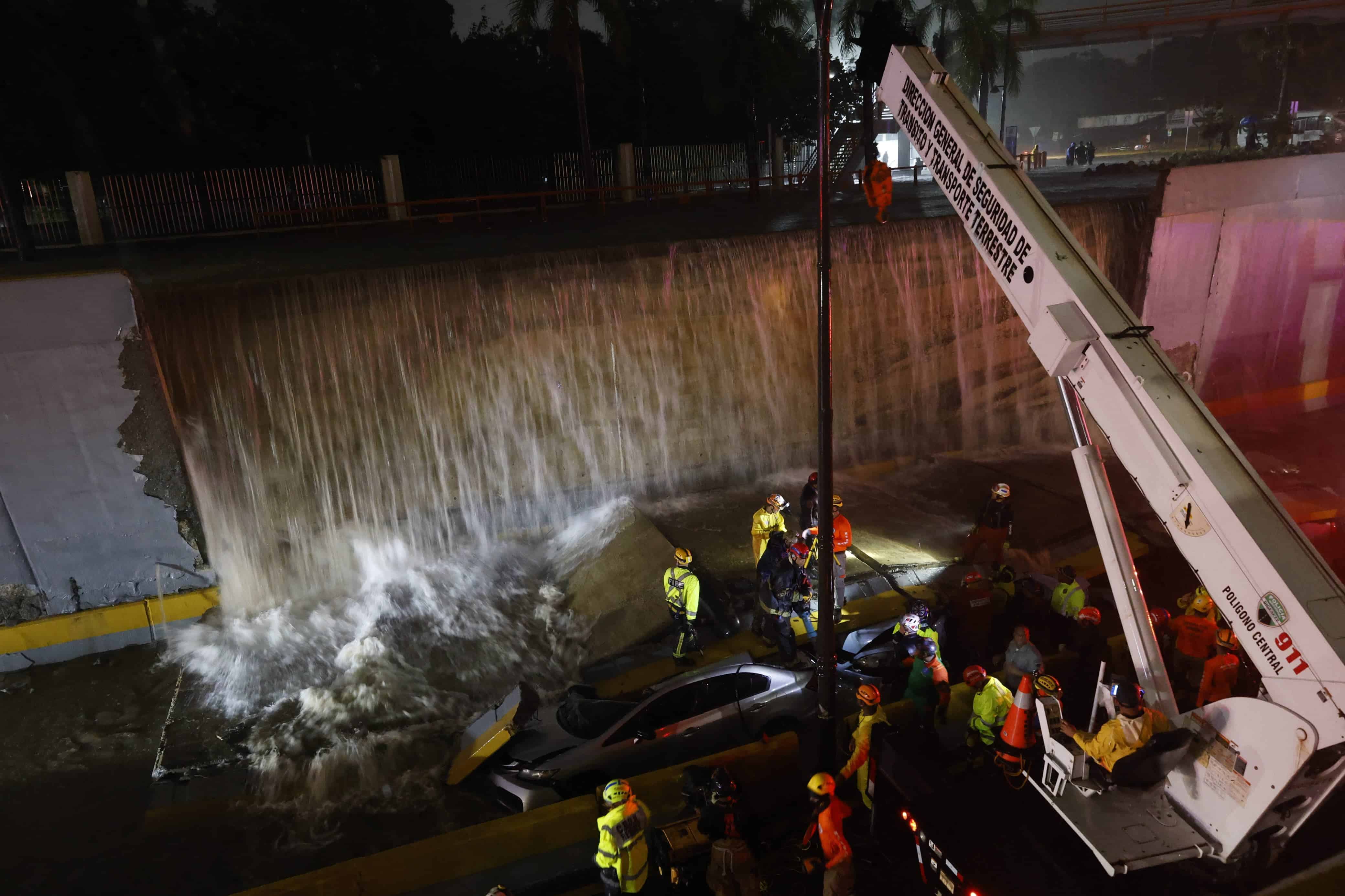 Trabajadores del MOPC se auxilian de una grúa para liberar a las personas atrapadas en el colapso de una pared en el paso a desnivel de la avenida 27 de Febrero.