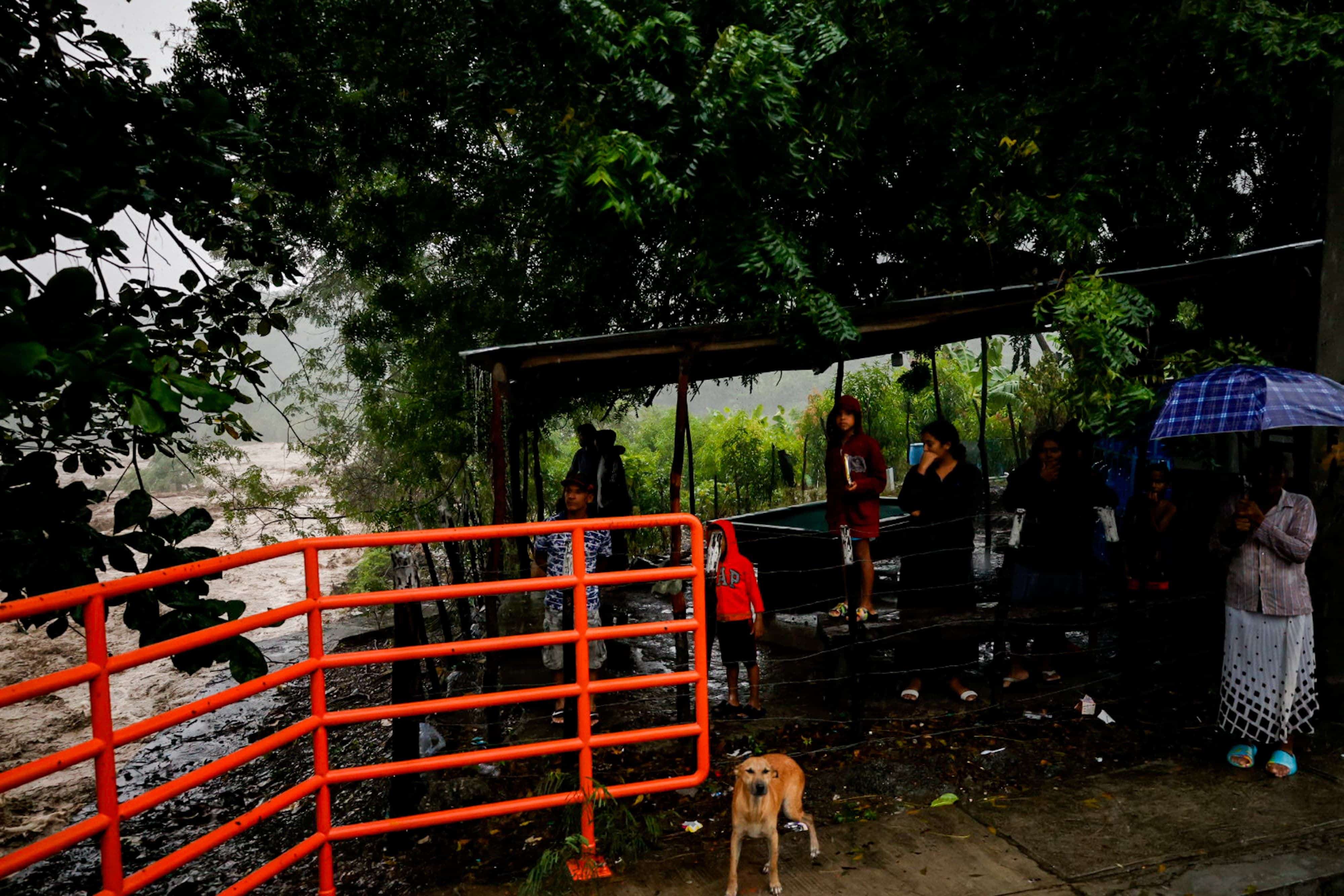 Familias contemplan la inusual fuerza del agua en Arroyo Blanco.