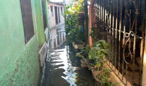 Residentes en Nueva Isabela caminan sobre aguas contaminadas tras disturbio tropical