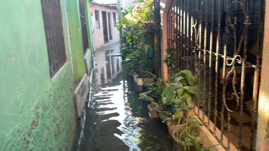 Residentes en Nueva Isabela caminan sobre aguas contaminadas tras disturbio tropical