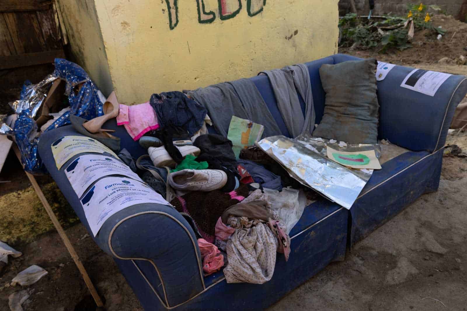 Joven pone a secar al sol los pocos diplomas que pudo salvar tras las inundaciones. 