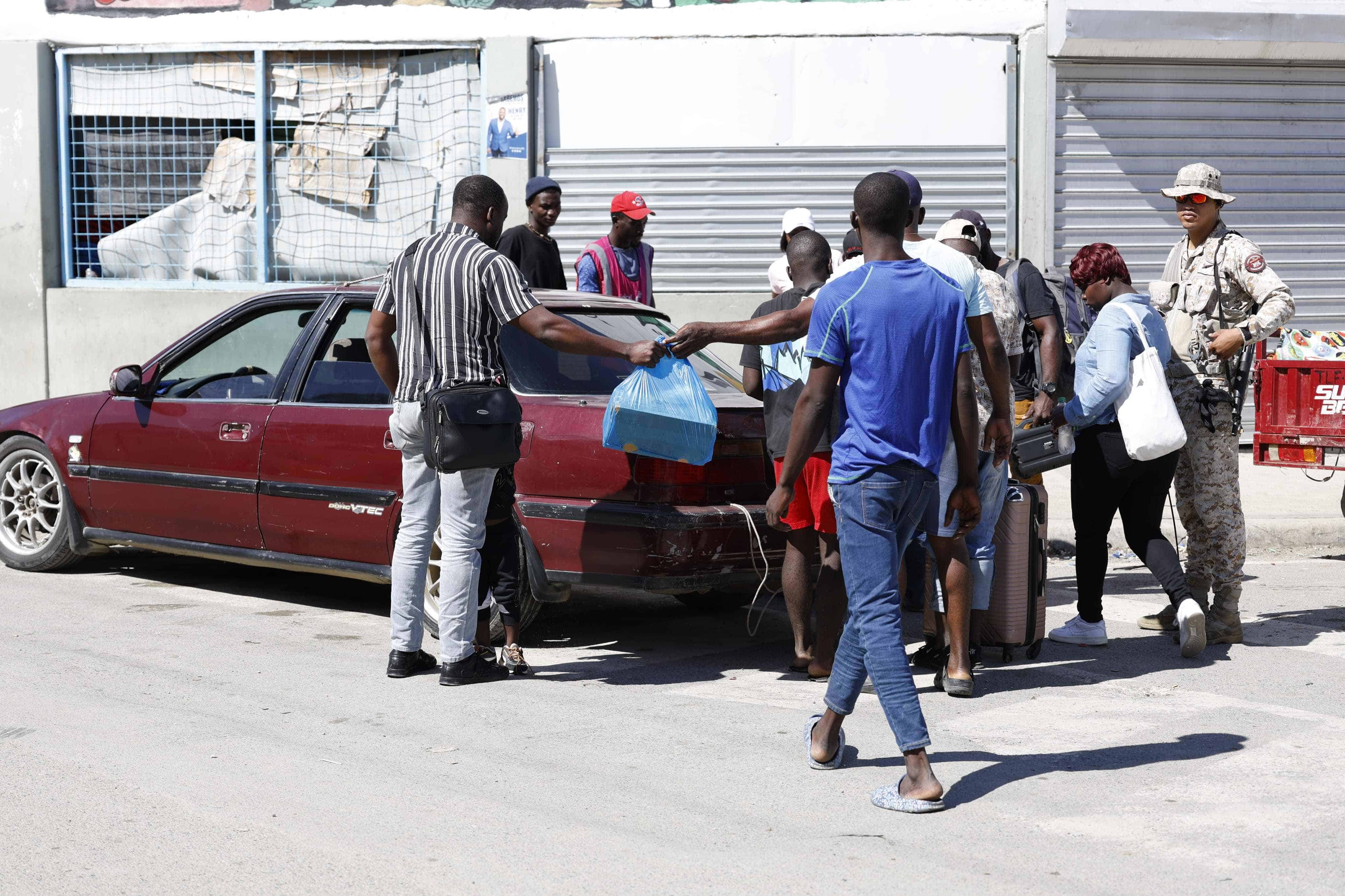 Agente del Cesfront junto a nacionales haitianos.