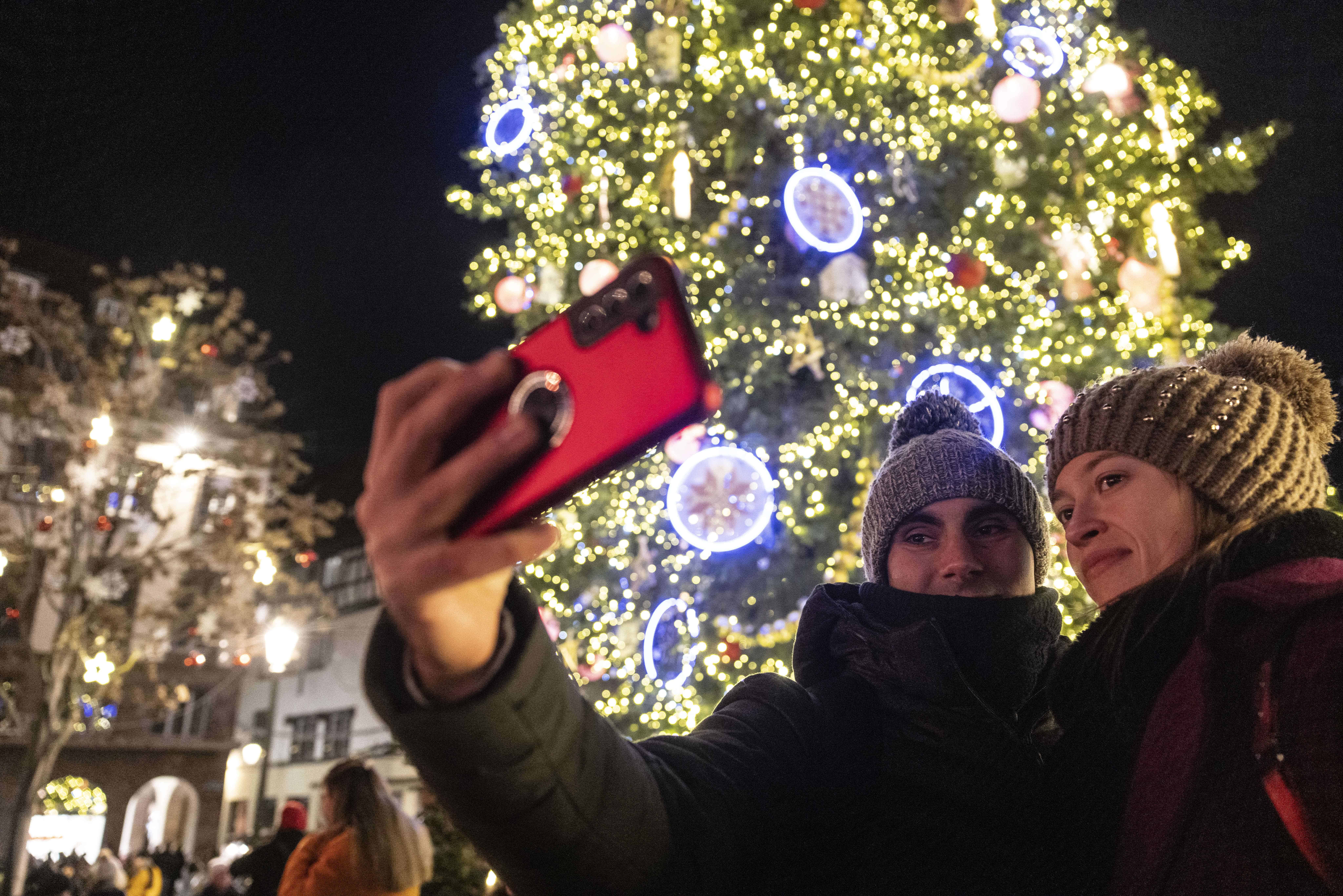 Los visitantes se toman una selfie frente a un gran árbol de Navidad, en Estrasburgo, este de Francia, el viernes 24 de noviembre de 2023.