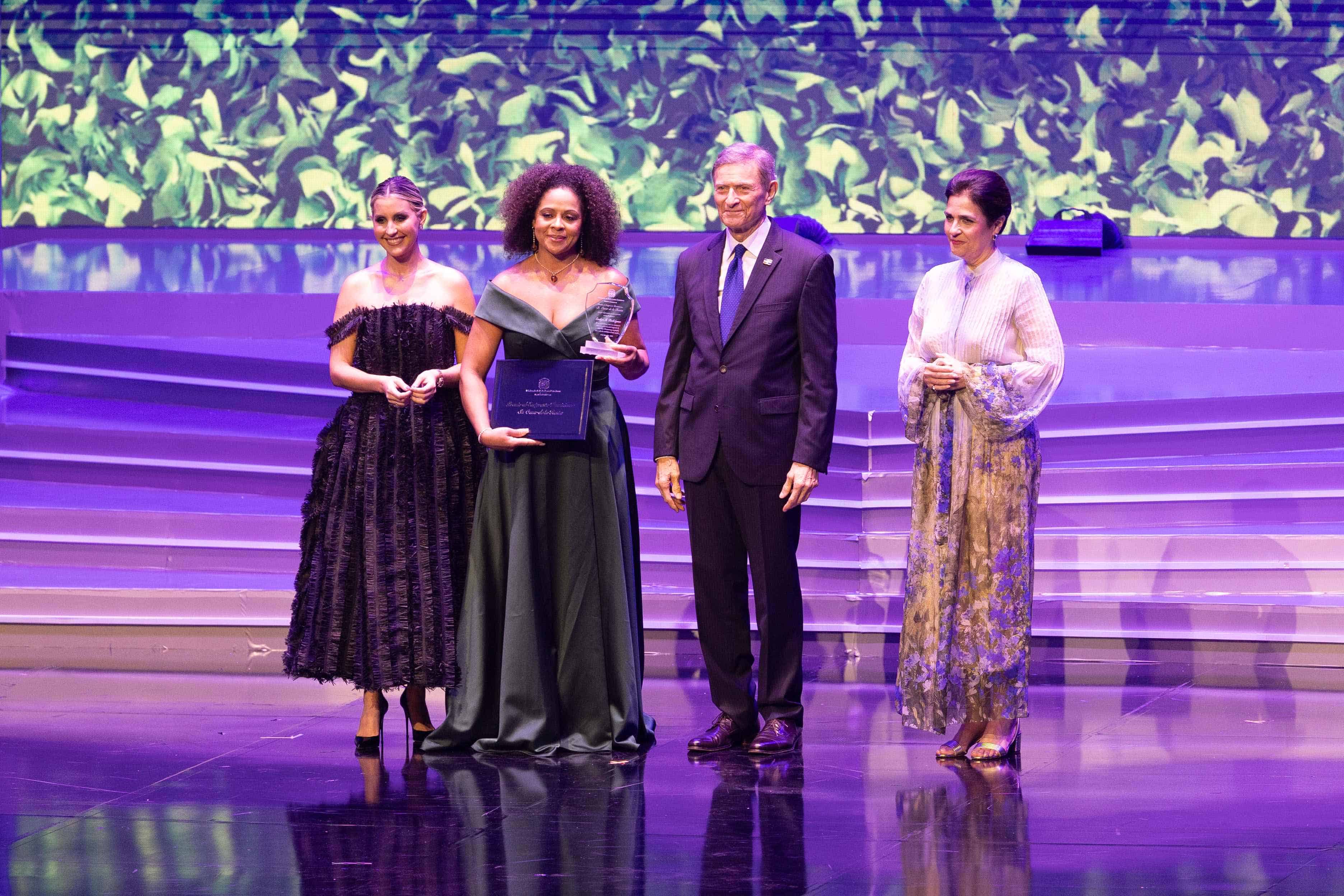 Evelyn Miosotis Rodríguez recibe el reconocimiento de la mano de Alejandra Castillo, Roberto Álvarez y María Amalia León.