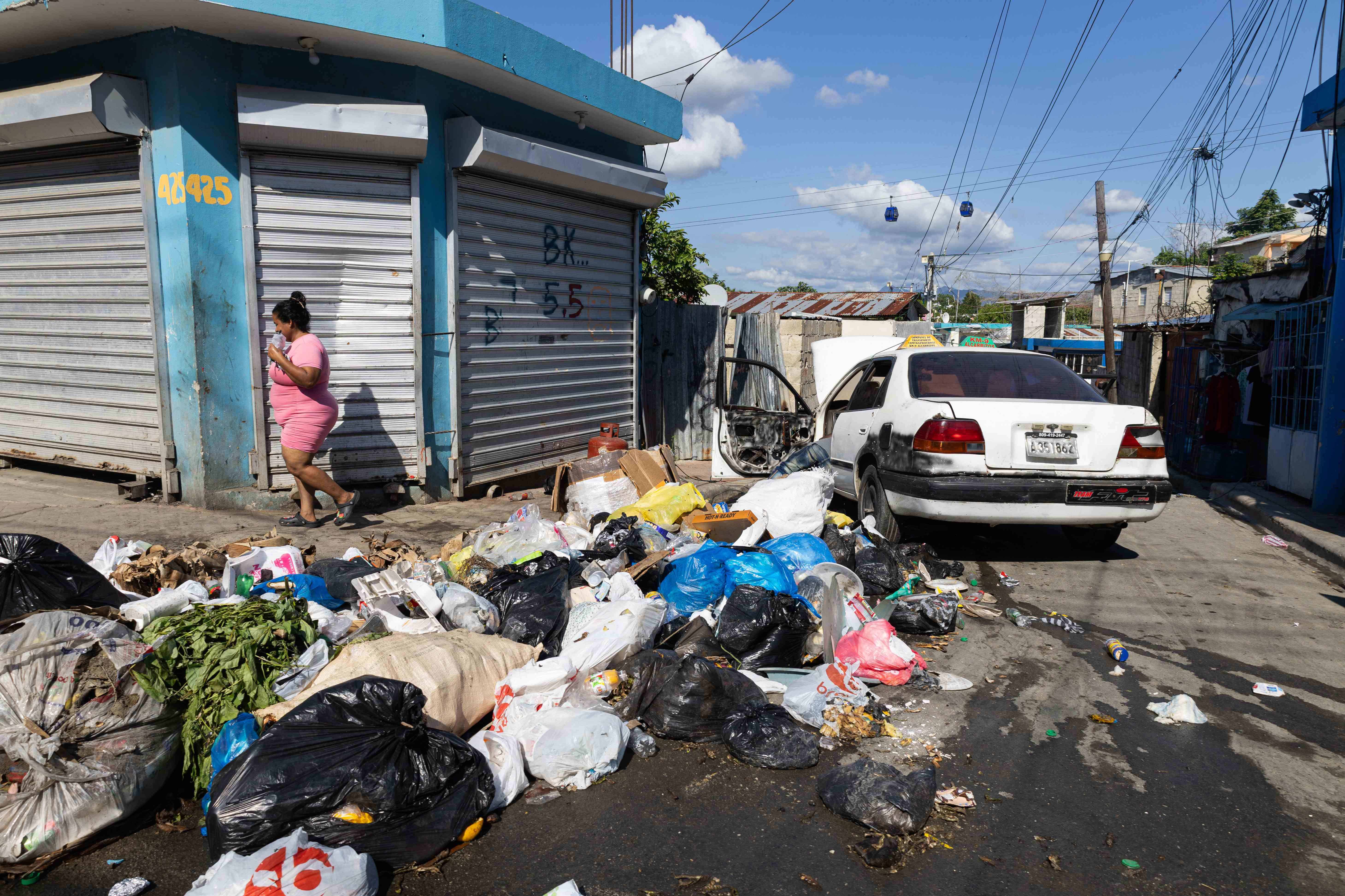 Otra calle casi intransitable de basura en Los Alcarrizos.