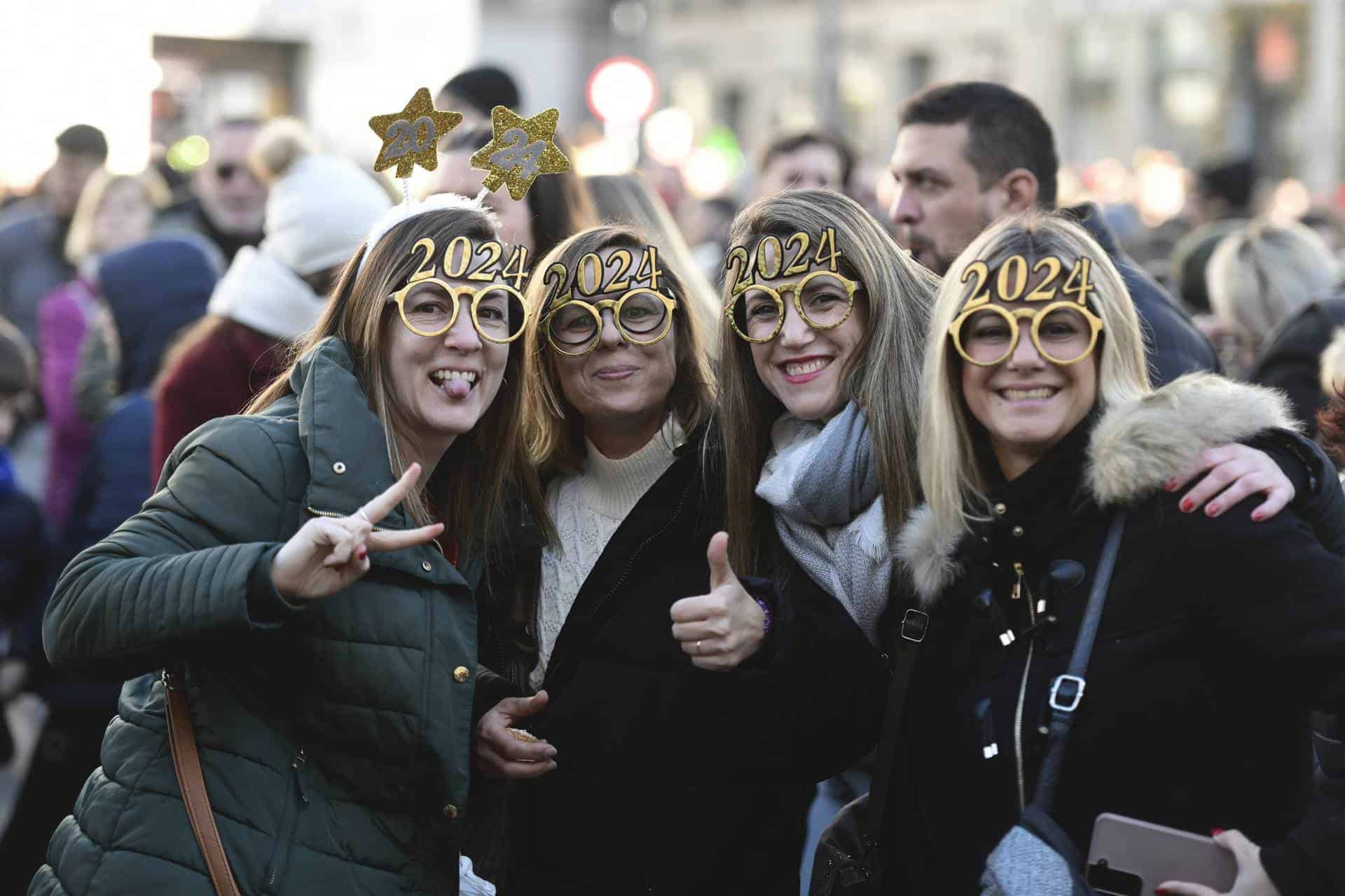 Varias personas celebran durante el ensayo de las campanadas de Fin de Año en la Puerta del Sol las preuvas.