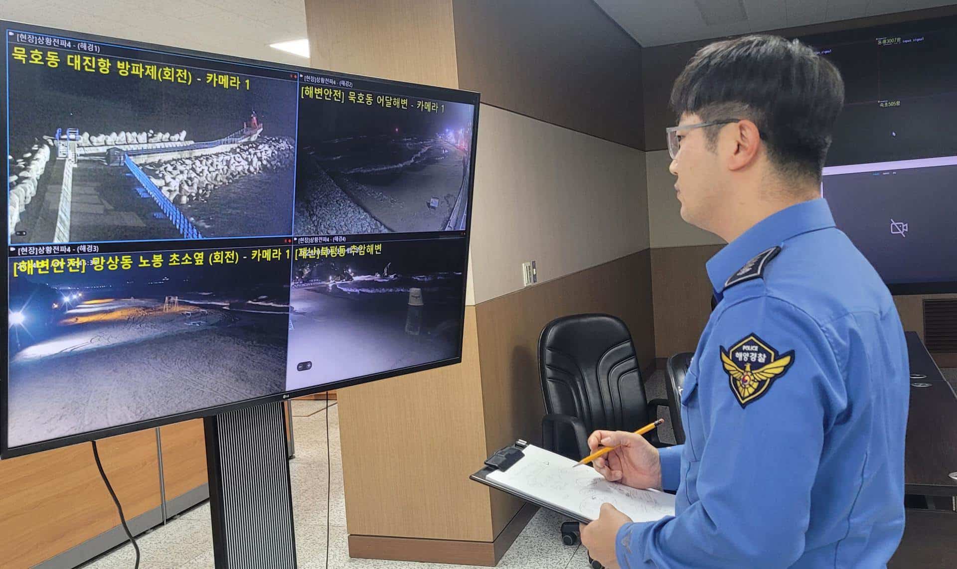 Un oficial de la Guardia Costera de Corea del Sur monitorea transmisiones de televisión por circuito cerrado que muestran playas y áreas costeras, dentro de la sede regional en Donghae, después de tsunamis menores causados  por un gran terremoto frente a la costa de Japón.