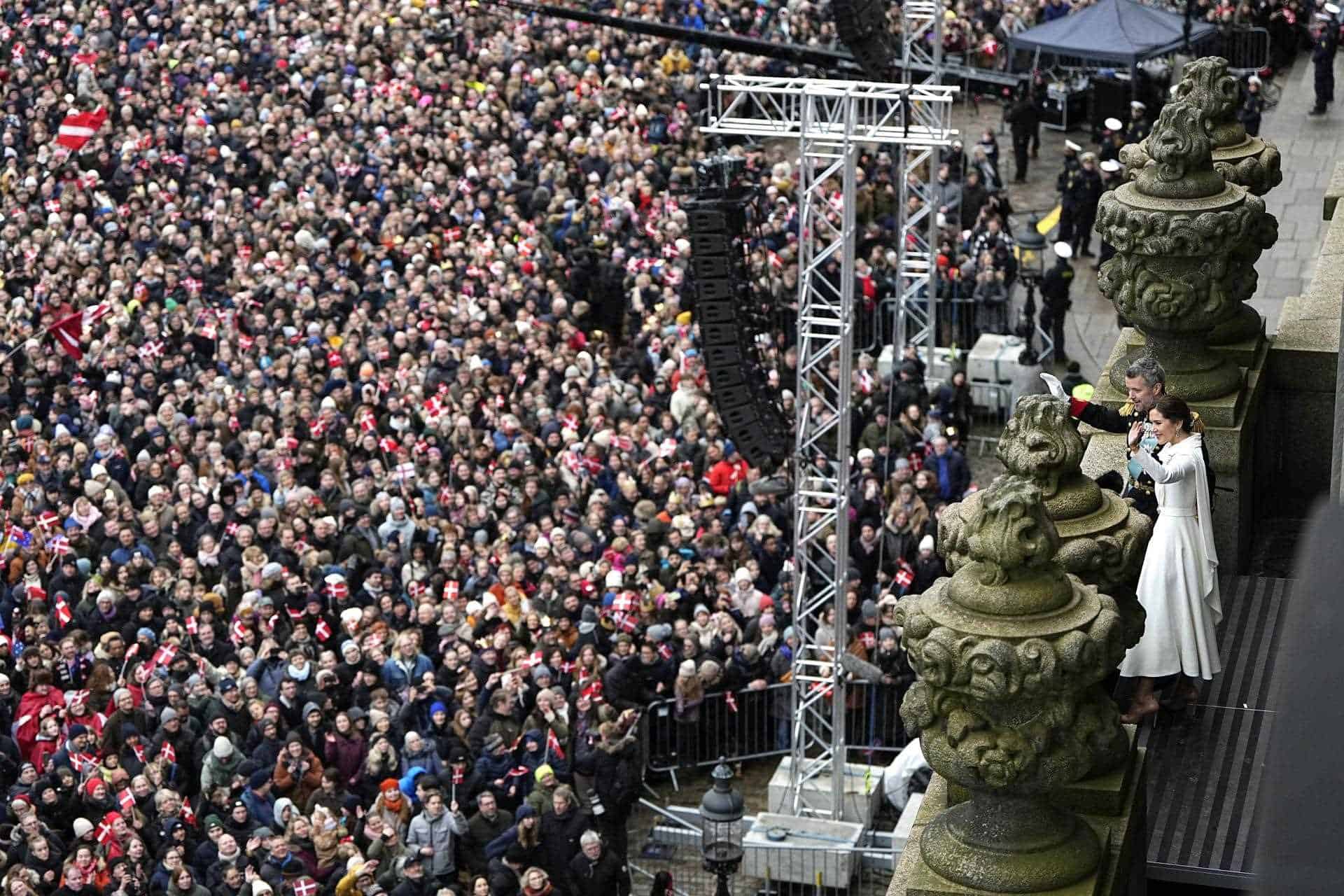 Los monarcas saludan a la multitud desde el balcón del palacio.