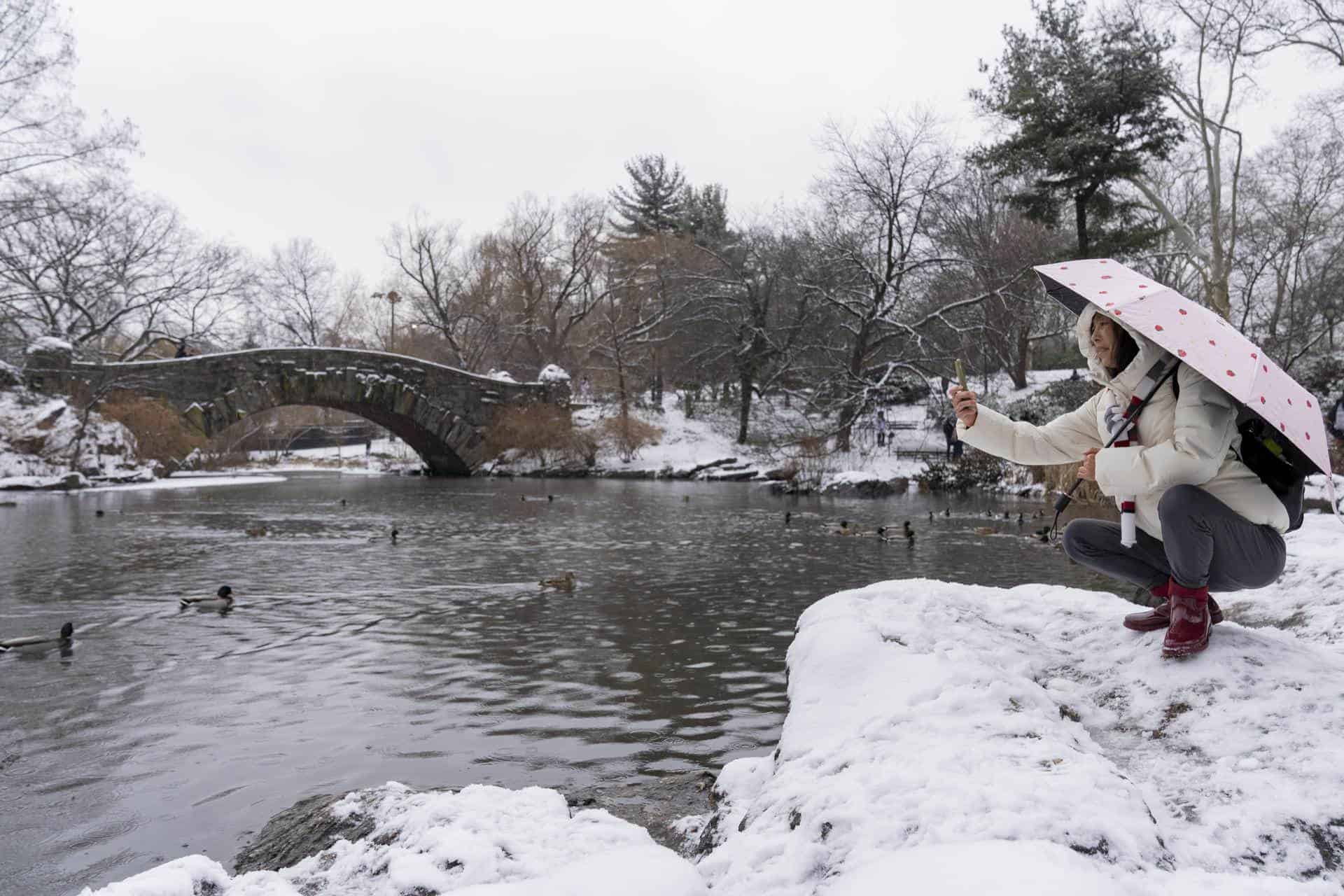 Una persona toma una fotografía al paisaje nevado en el lago en Central Park hoy, en Nueva York (EE.UU.). 