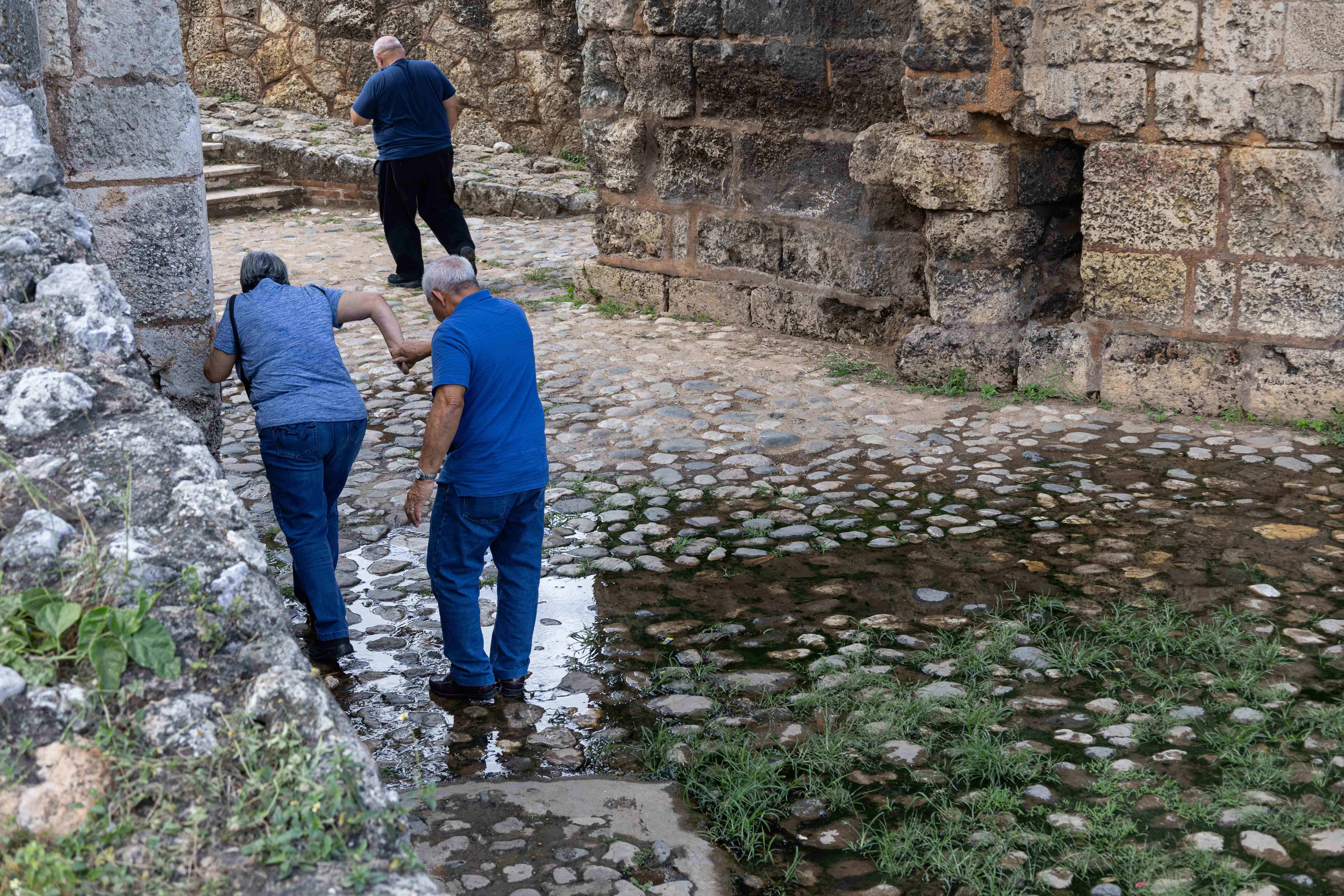 Turistas busca cruzar por un lado donde haya menos agua contaminada.