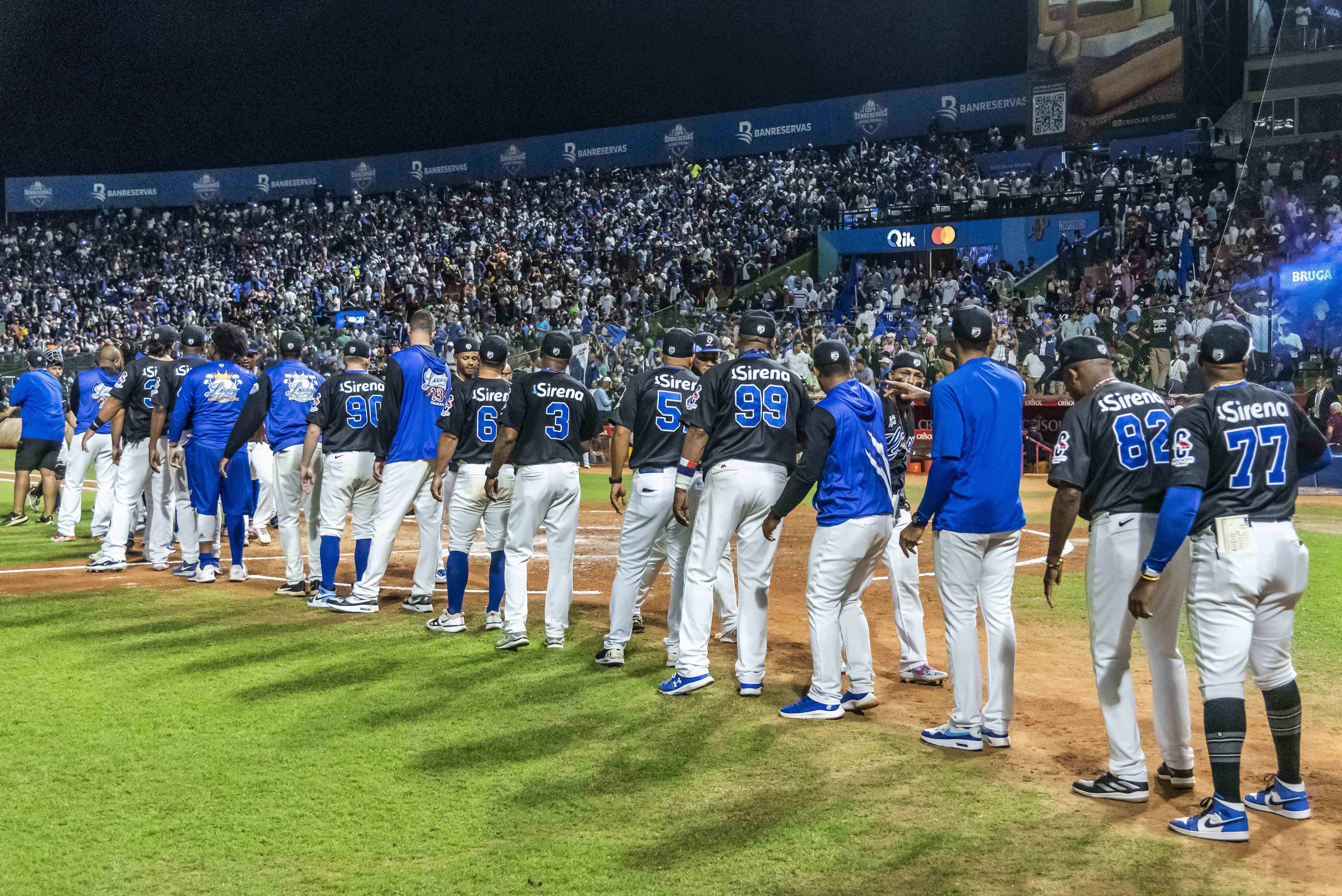 Los jugadores del Licey se saludan entre ellos mientras celebran el empate de la serie