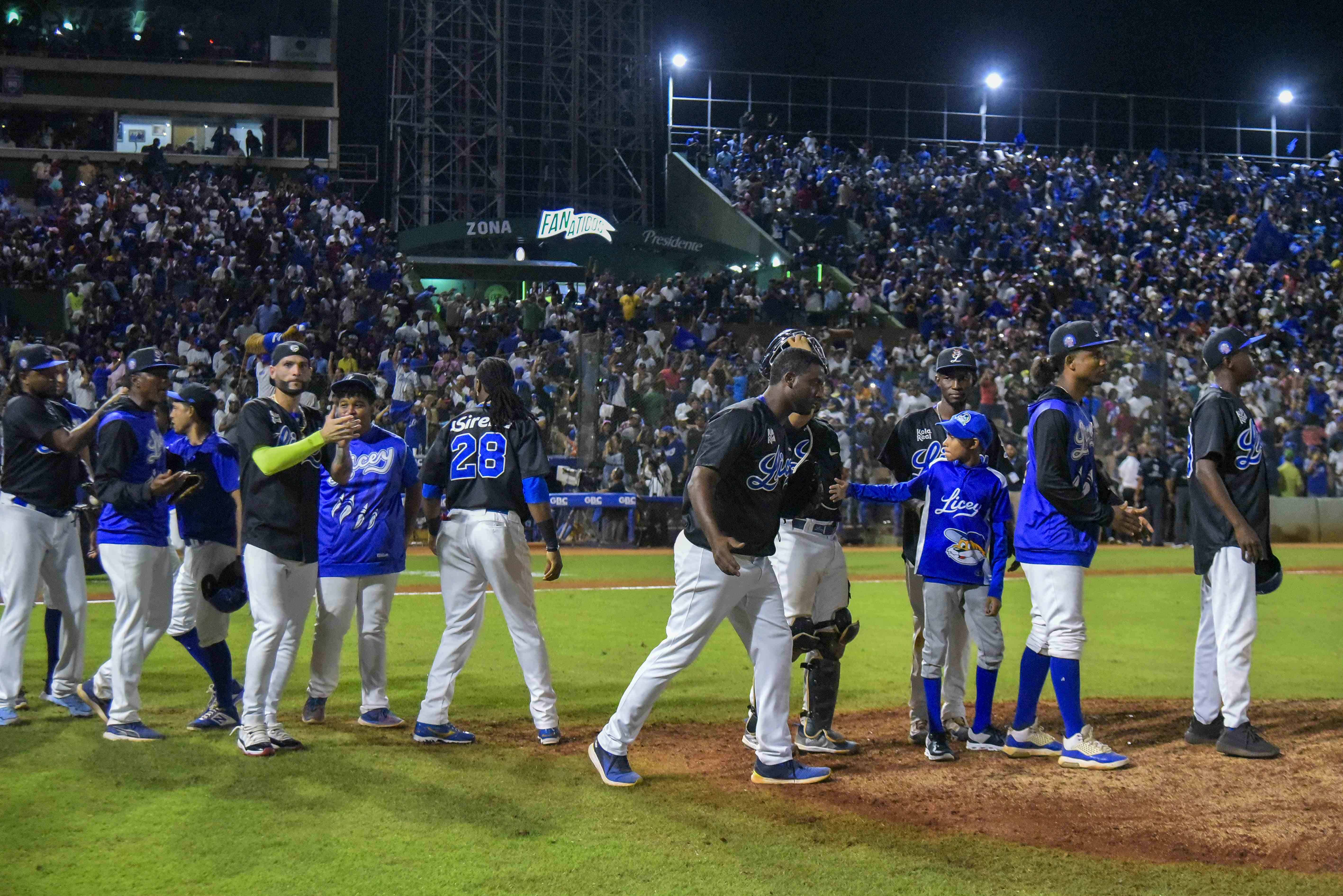 Los jugadores del Licey se saludan unos a otros y celebran el fin del encuentro