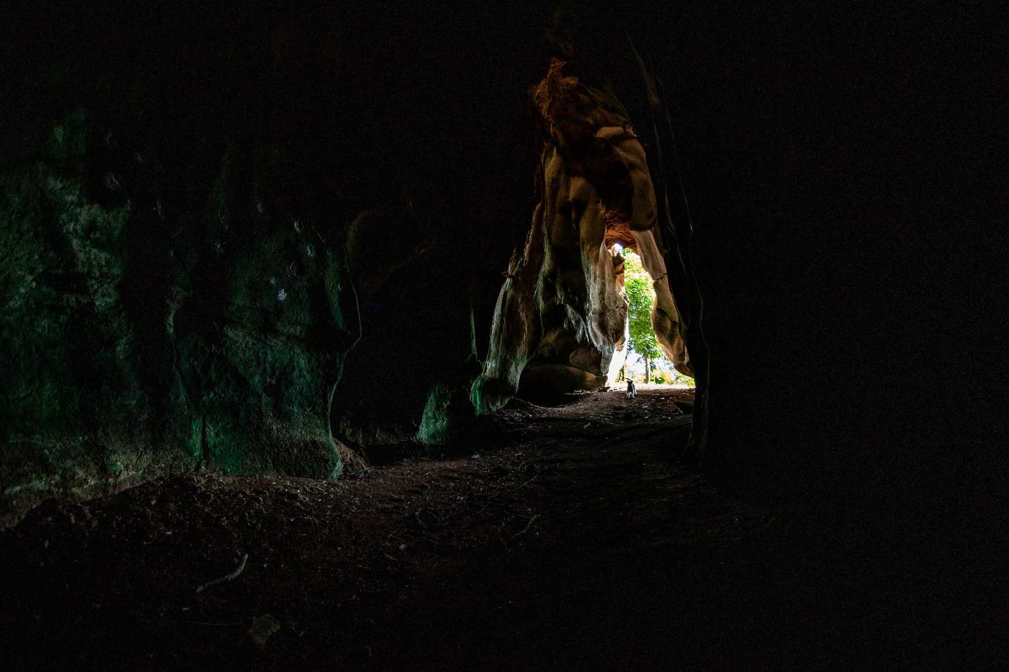 Timoteo Estévez alumbra con una linterna el pequeño pozo que da nombre a la cueva.