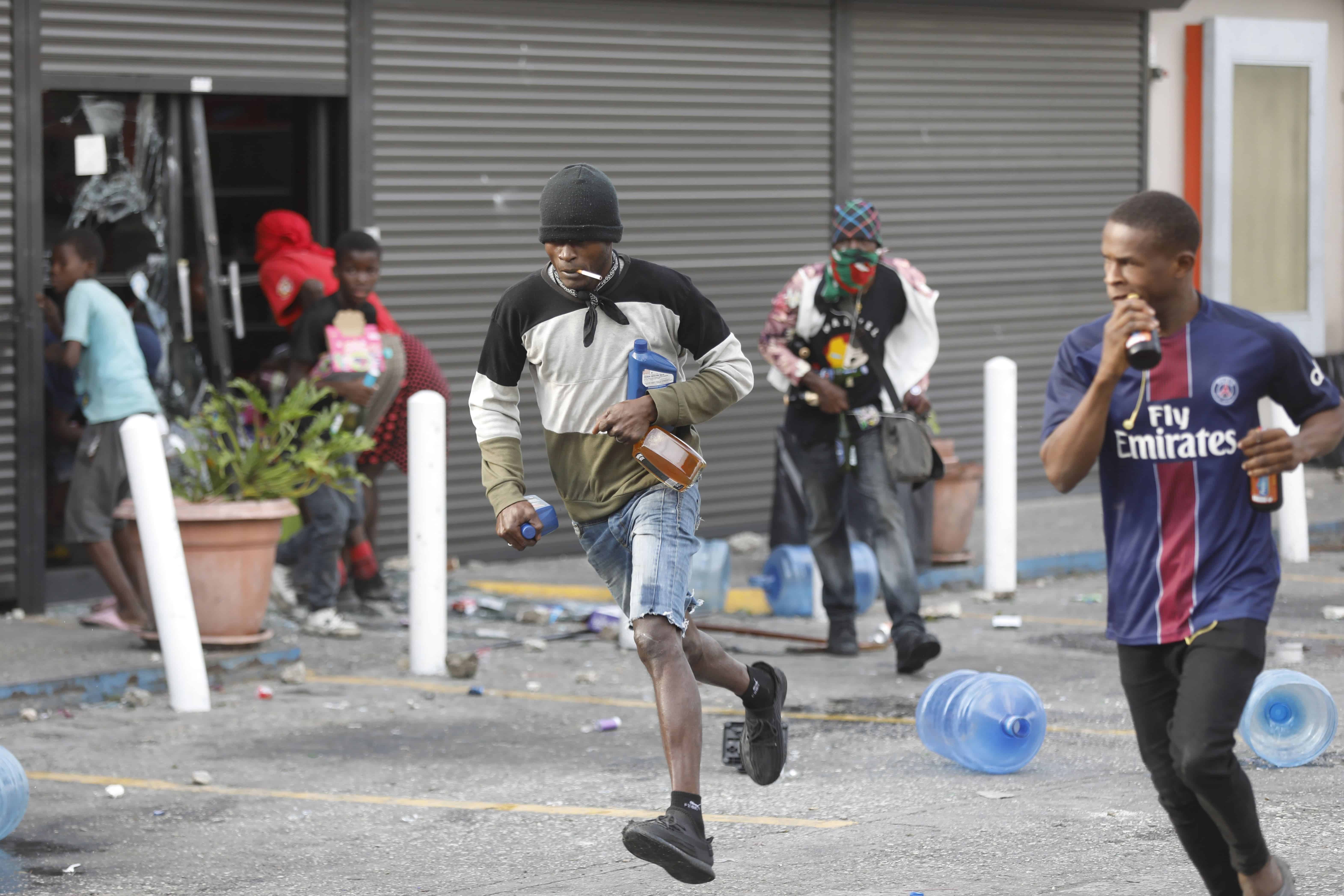 La gente se lleva artículos sacados de un supermercado, en el segundo día consecutivo de una protesta contra el primer ministro Ariel Henry, exigiendo su destitución, en Puerto Príncipe, Haití, el martes 6 de febrero de 2024.