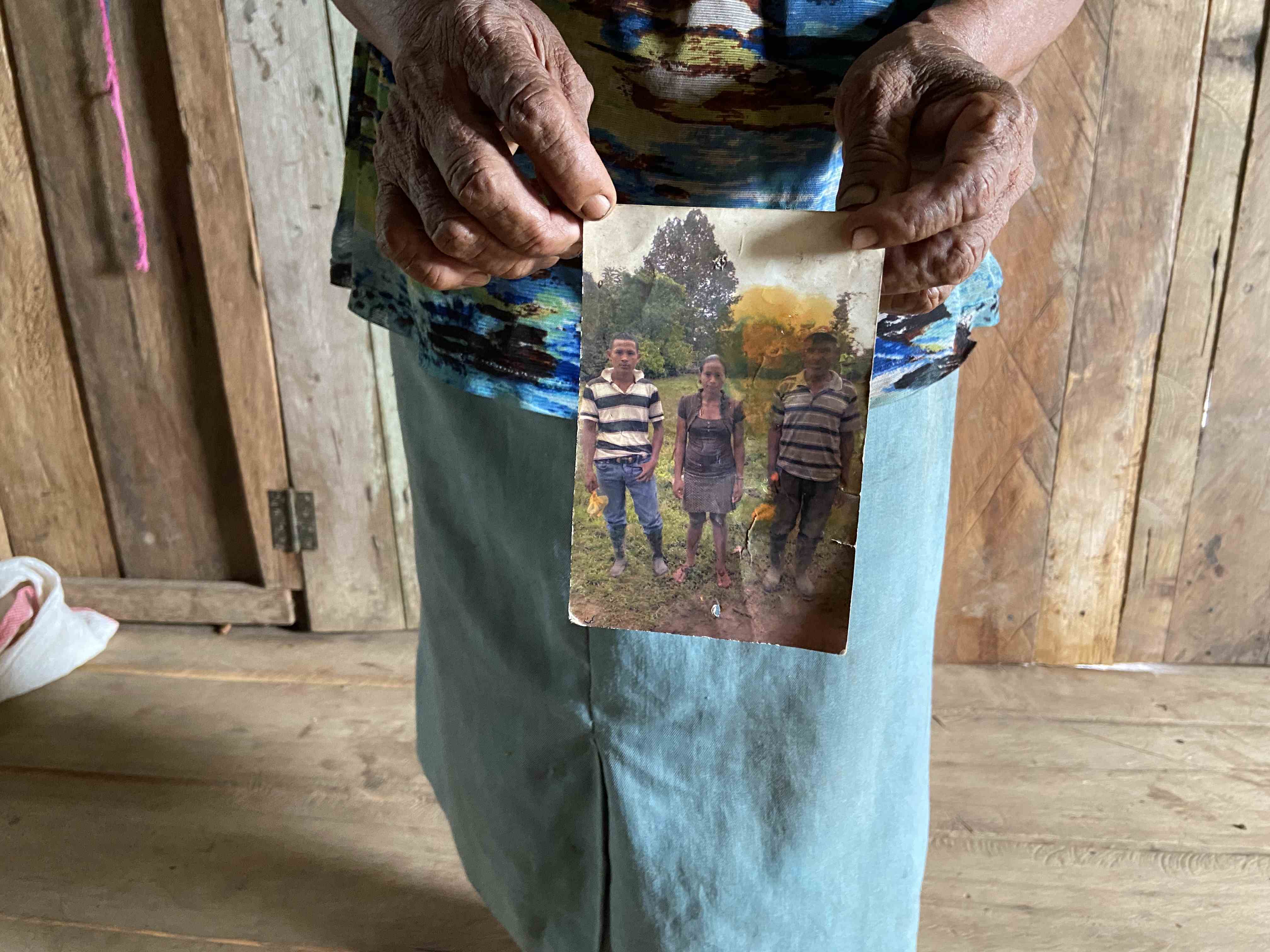 Macaria Fenly sostiene una fotografía de su hijo German y Marling Martínez Fenly, asesinados en 2015 y 2022, respectivamente. <br>
