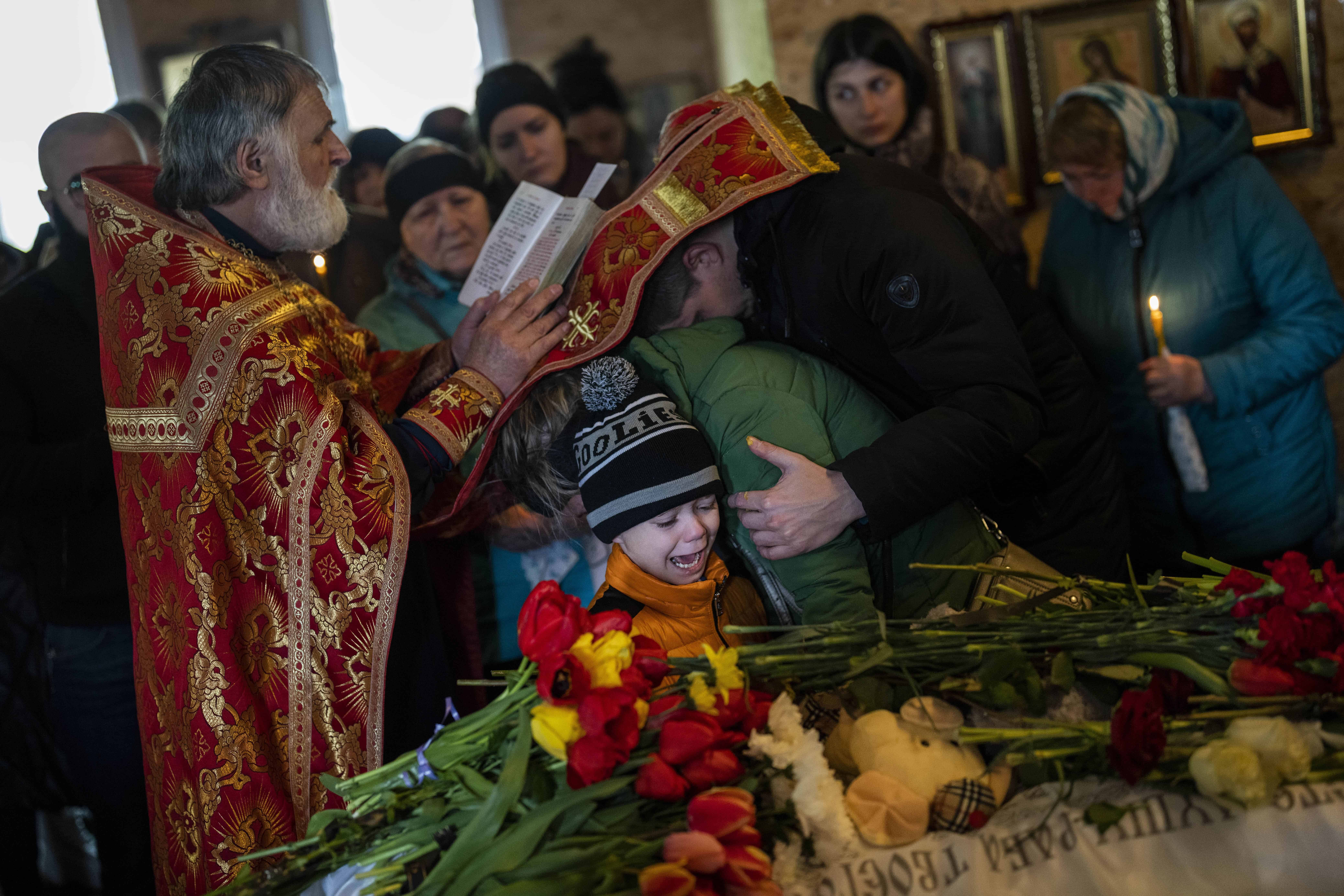 Mykhayl Shulha (centro) llora junto al ataúd de su hermana, Sofia Shulha, durante su funeral en Uman, en el centro de Ucrania, el 30 de abril de 2023. Sofia Shulha, de 11 años, murió en un ataque a un edificio residencial durante la guerra con Rusia.