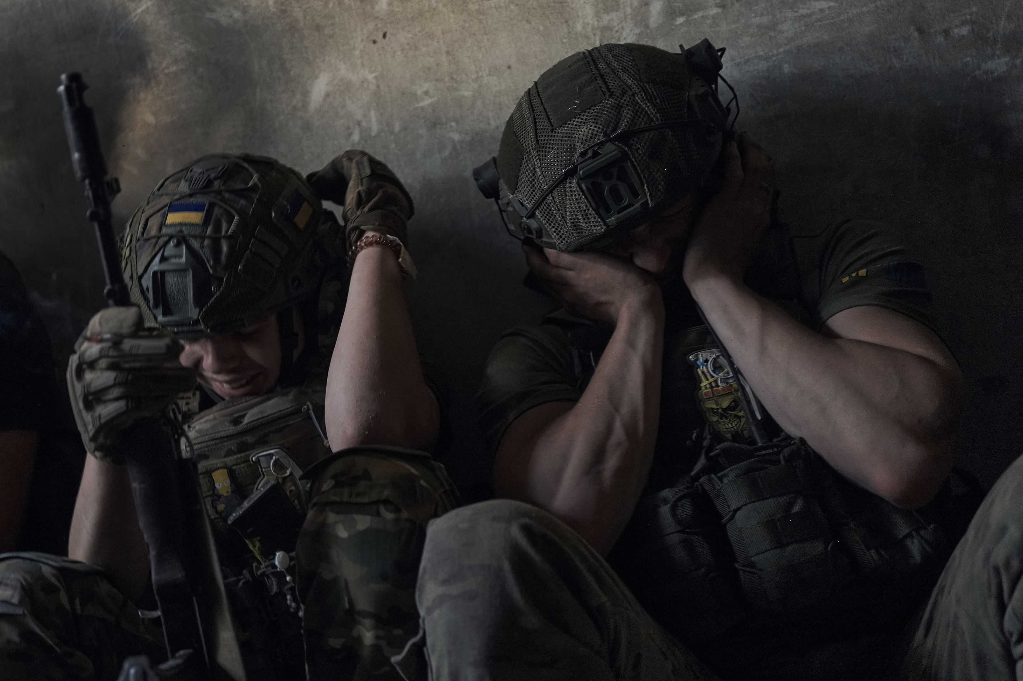 Soldados ucraniano se cubren los oídos para protegerse del ruido de los bombardeos rusos, en un refugio en el frente en la provincia de Zaporiyia, Ucrania, el 2 de julio de 2023.