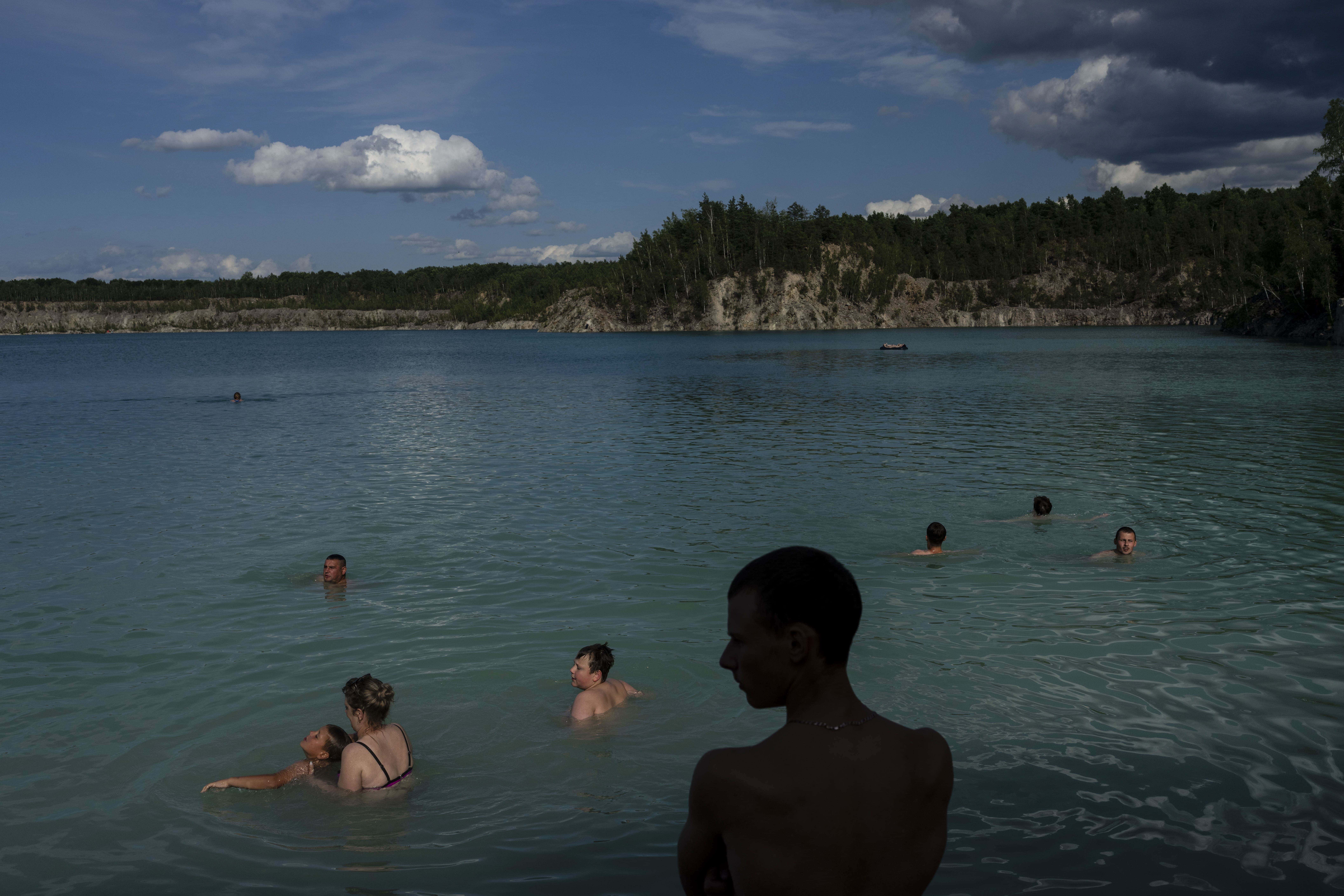 Varias personas nadan en un lago cerca de Druzhbivka, en la región ucraniana de Zhytomyr, el 21 de julio de 2023.