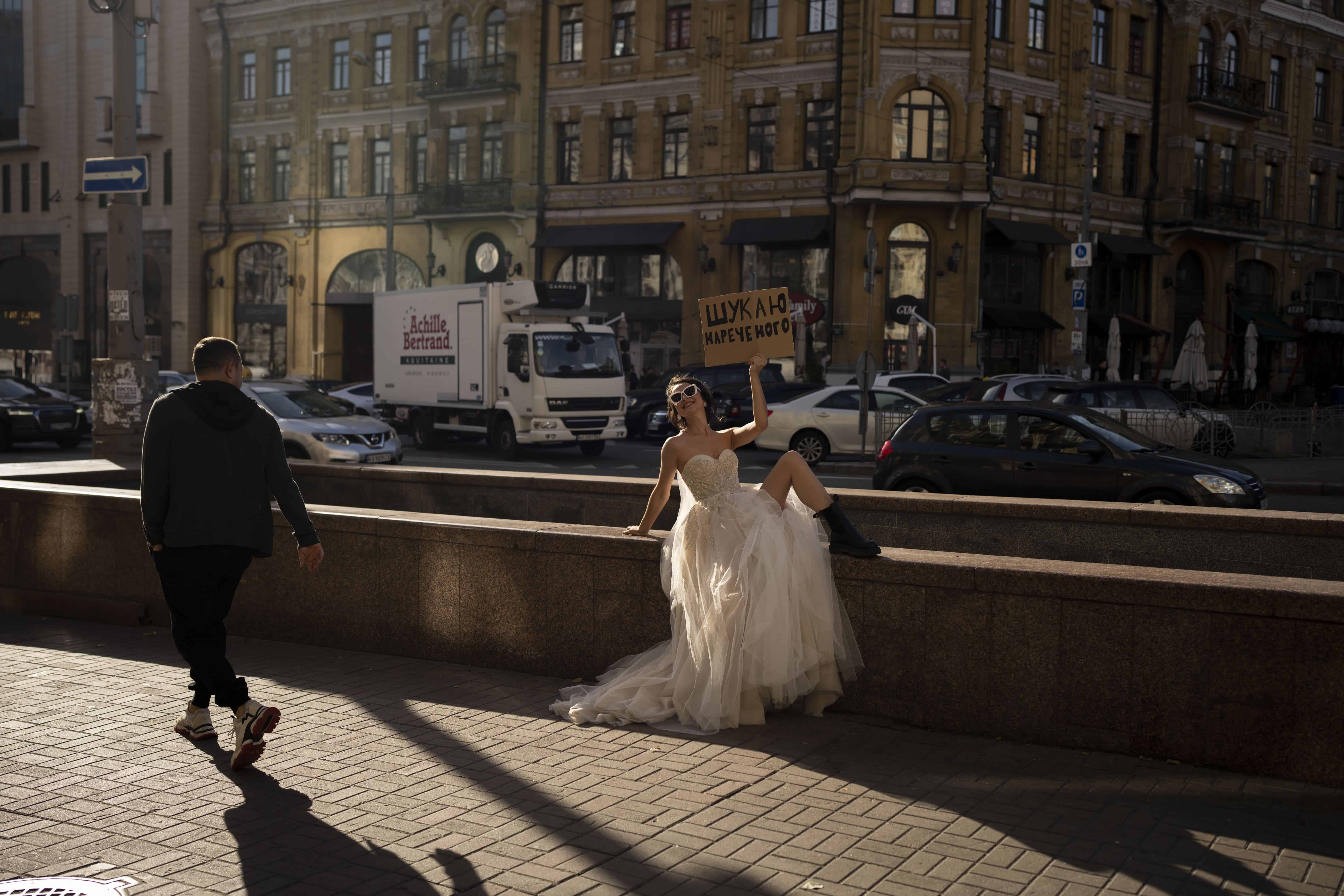 Una mujer posa para una campaña en redes sociales en Kiev, Ucrania, el 31 de octubre de 2023. El cartel dice Buscando un novio.