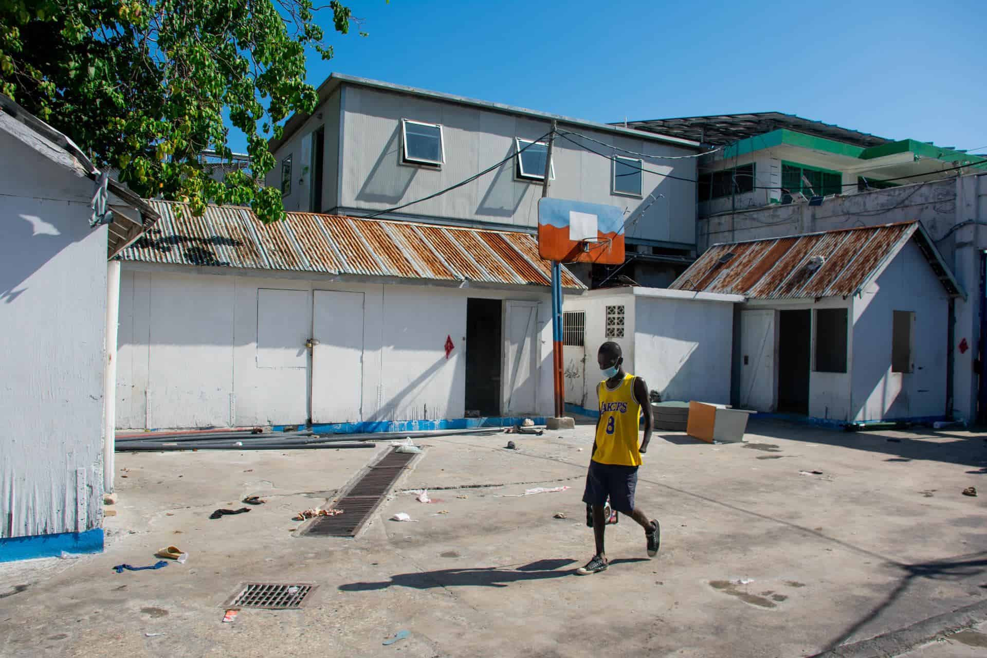 Un prisionero camina en el interior de la Penitenciaria Nacional luego del ataque por parte de bandas armadas, este domingo en Puerto Príncipe (Haití). Al menos una decena de personas murió tras el ataque anoche a la prisión civil de Puerto Príncipe por parte de bandas armadas, que habrían liberado a numerosos delincuentes importantes durante su asalto al presidio.